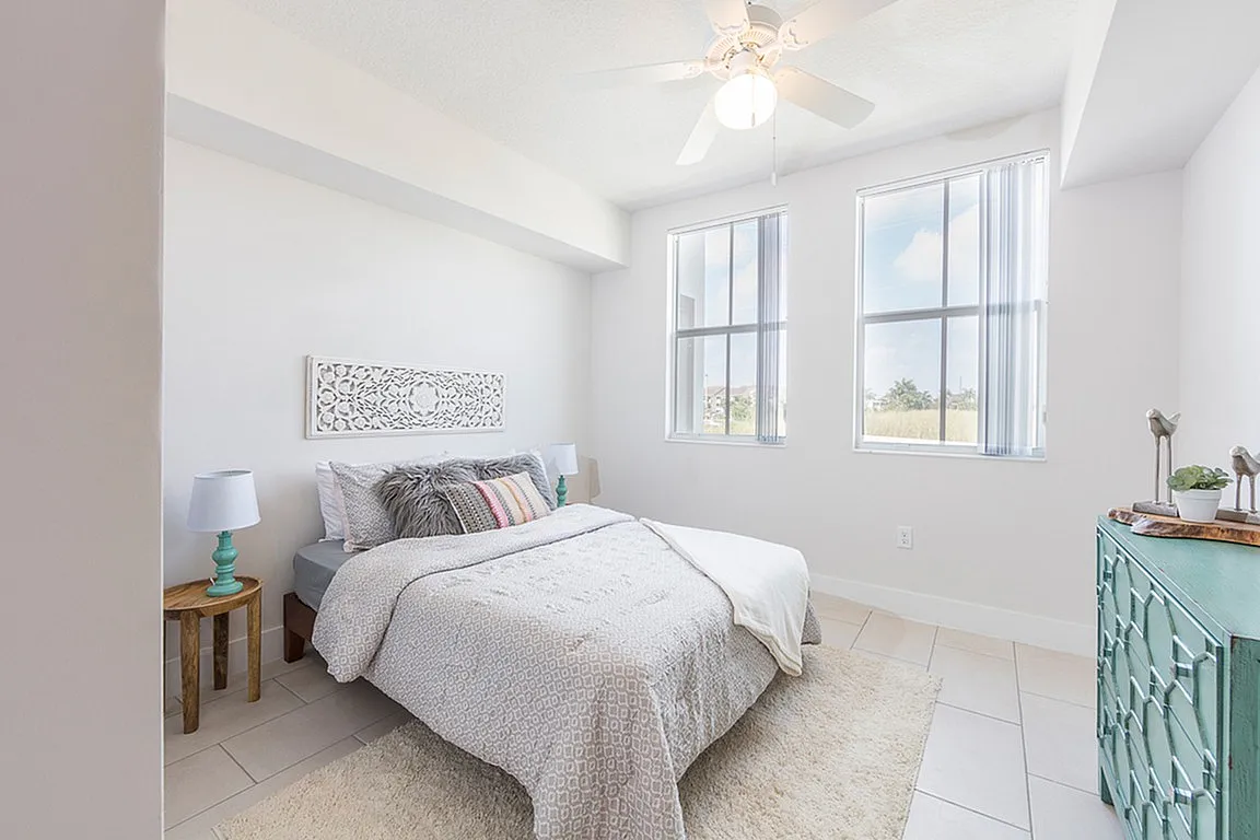 Bright and airy bedroom featuring elegant decor, large windows, and cozy furnishings for a serene escape.