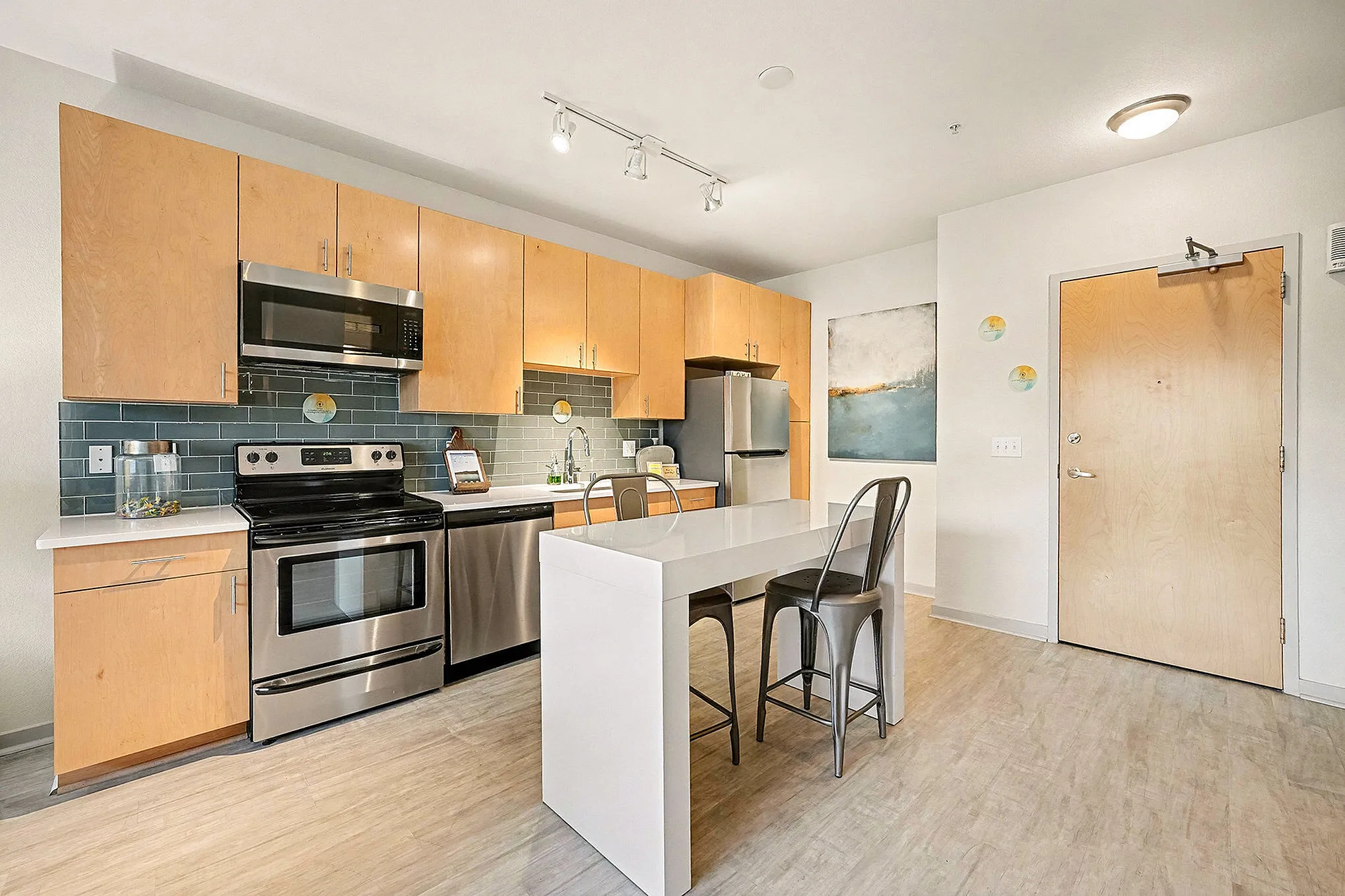 Modern kitchen with sleek stainless steel appliances, stylish wooden cabinets, and contemporary tile backsplash, creating a warm and inviting culinary space.