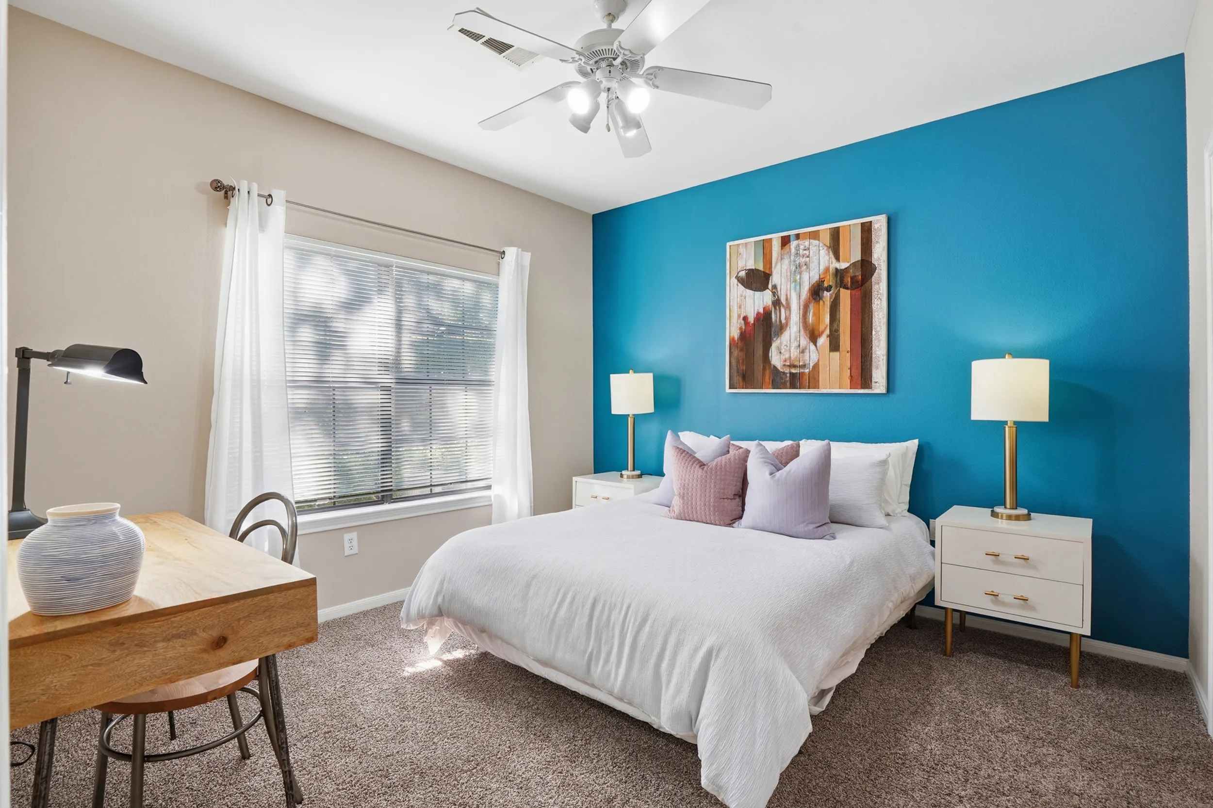 Cozy bedroom with elegant decor, featuring a stylish bedspread, ornate headboard, and warm lighting beside the window.