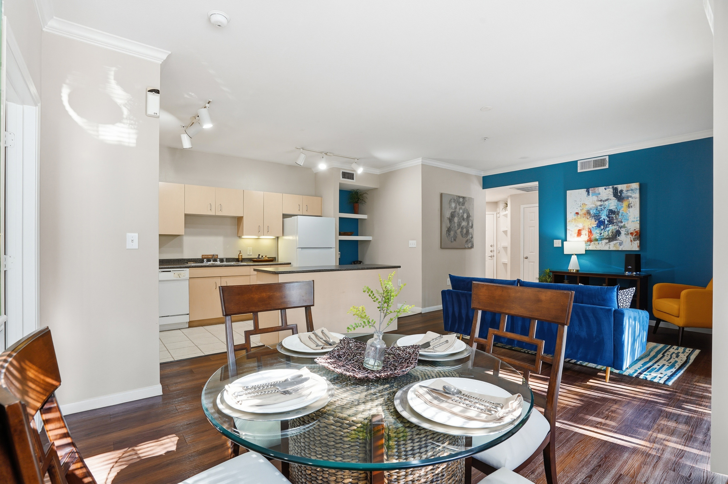 Charming dining area with elegant decor, wooden flooring, and a glimpse into a cozy bedroom, perfect for stylish living.