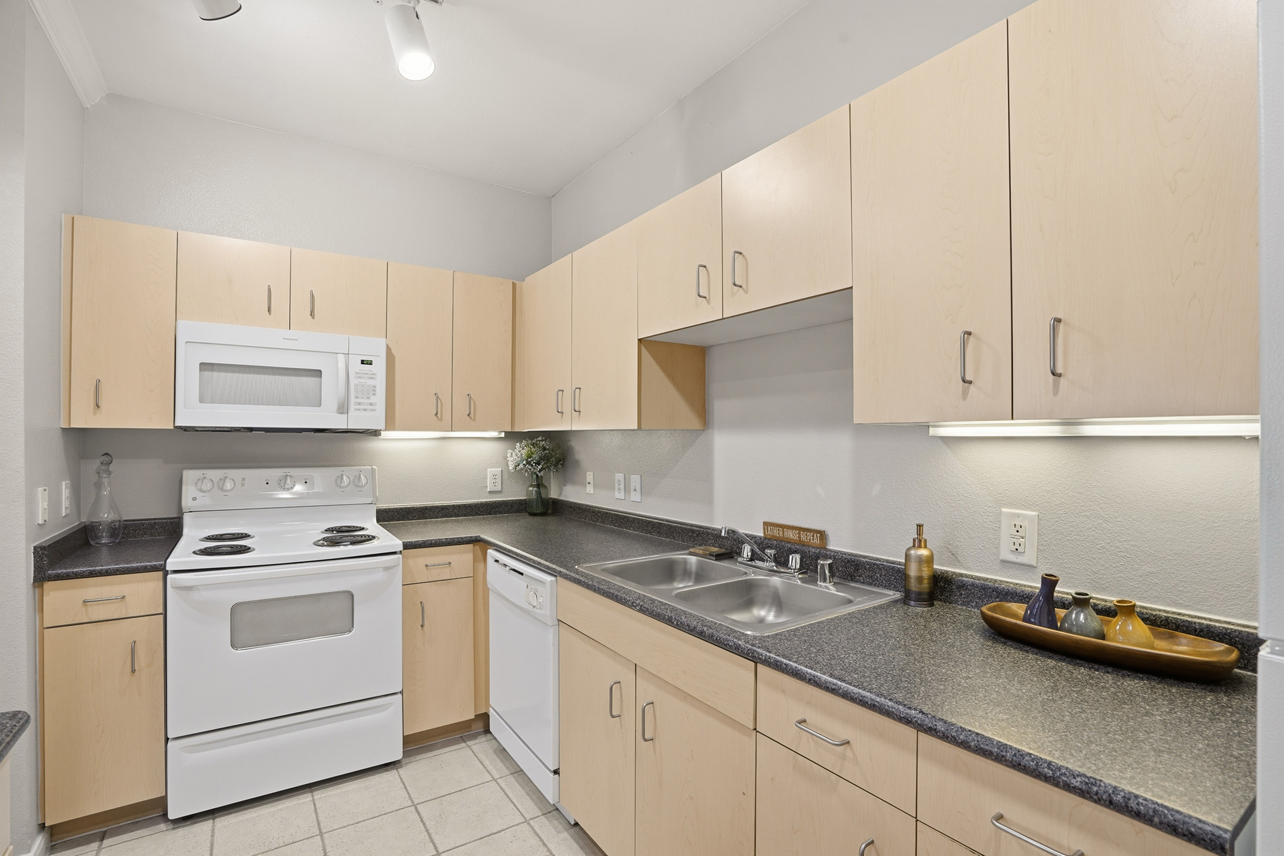 Elegant kitchen with light wood cabinets, modern appliances, and stylish countertops, creating a warm and inviting cooking space.