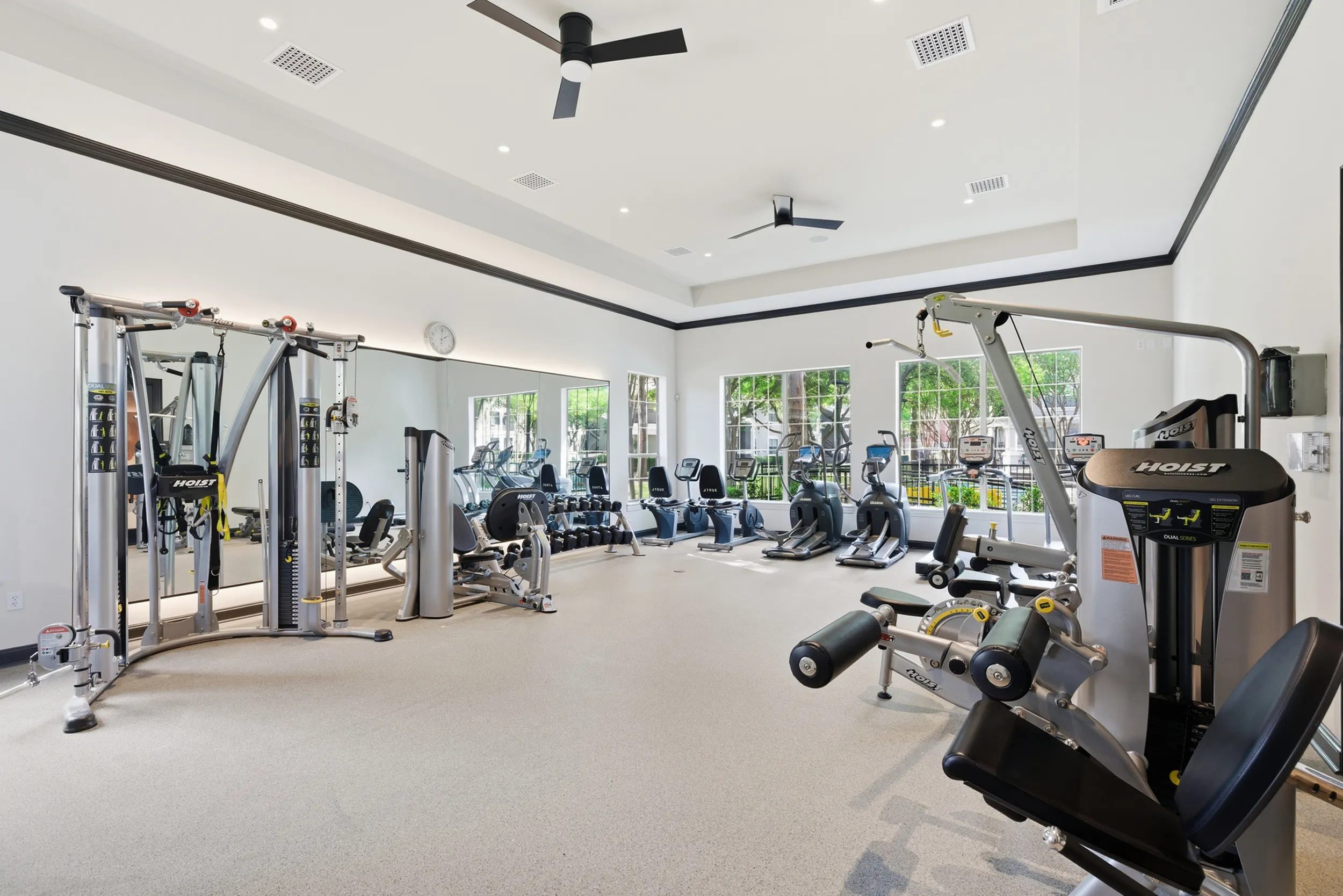 Bright and modern fitness center equipped with state-of-the-art exercise machines, free weights, and mirrored walls, offering a motivational workout environment.