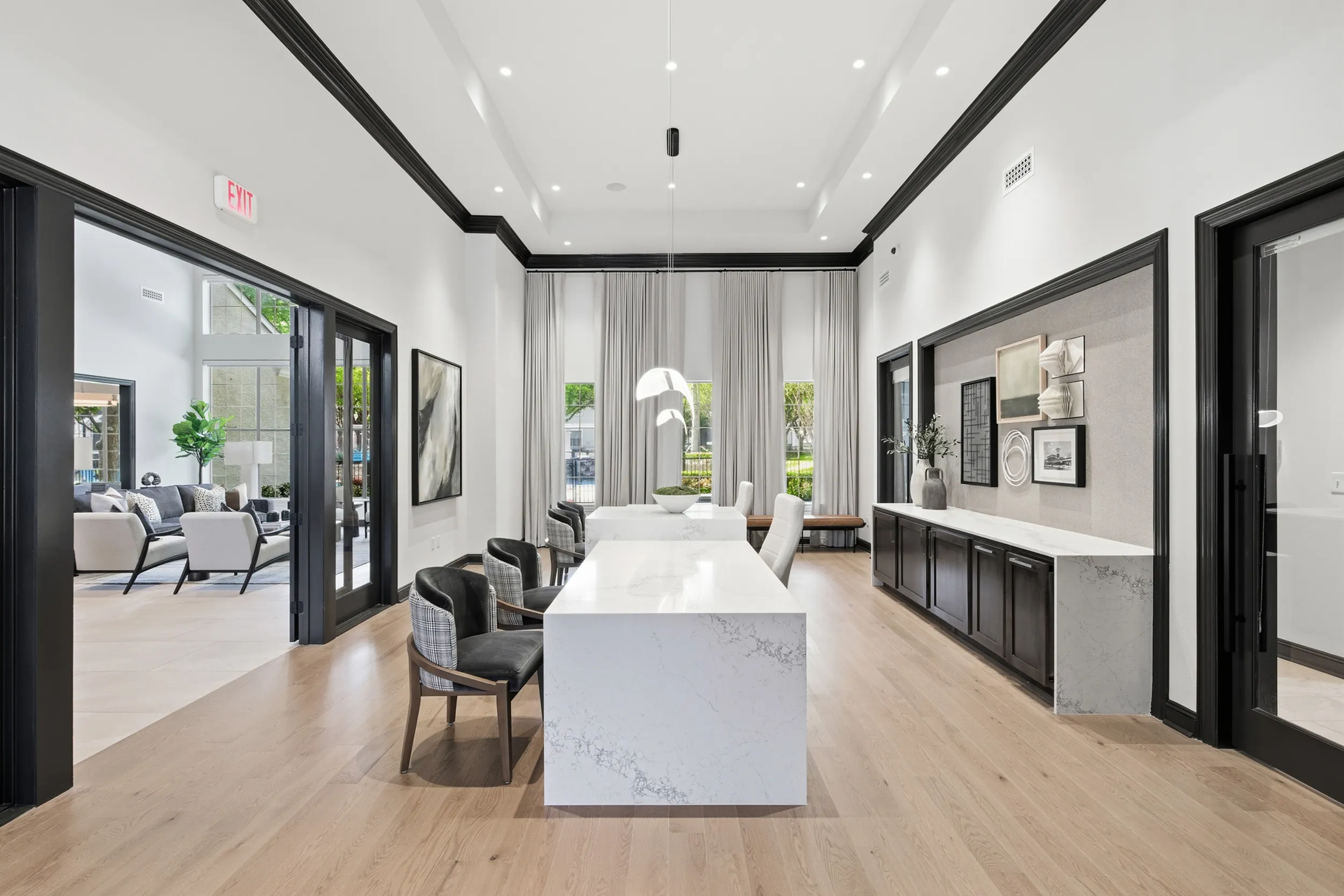 Elegant lobby area with high ceilings, modern decor, and natural light featuring comfortable seating and stylish wood furniture.