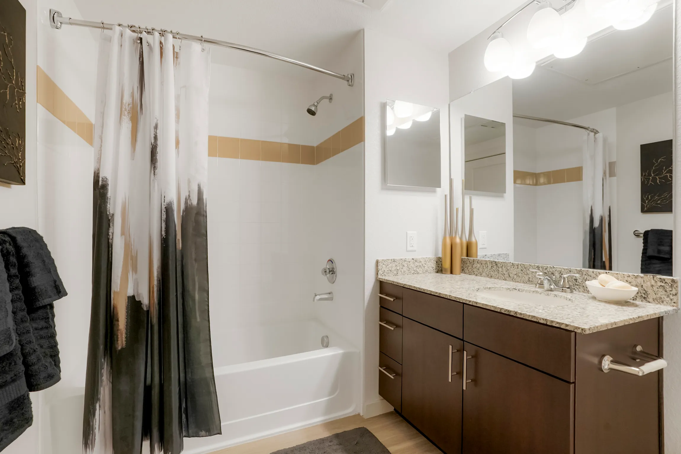 Elegant bathroom featuring modern vanity, granite countertop, and stylish wall decor.