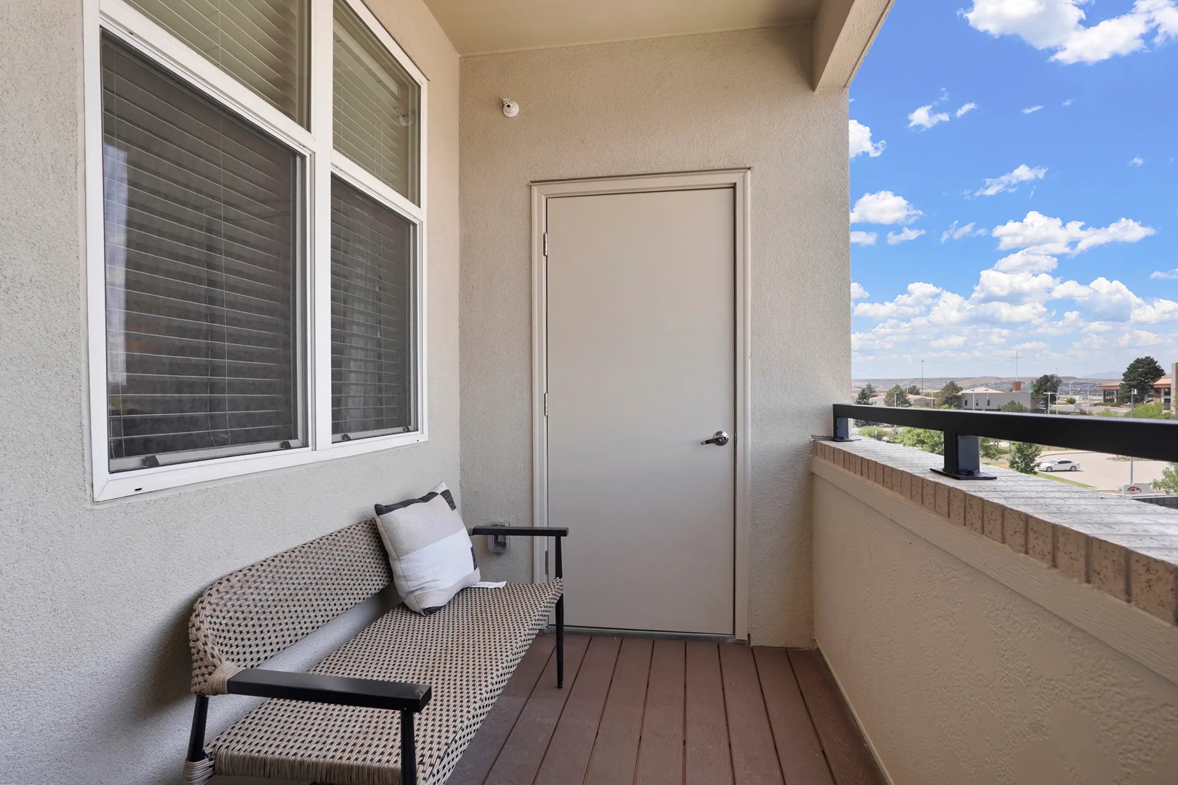 Charming balcony with two elegant white chairs and a vibrant yellow side table, perfect for relaxing and enjoying the serene view.