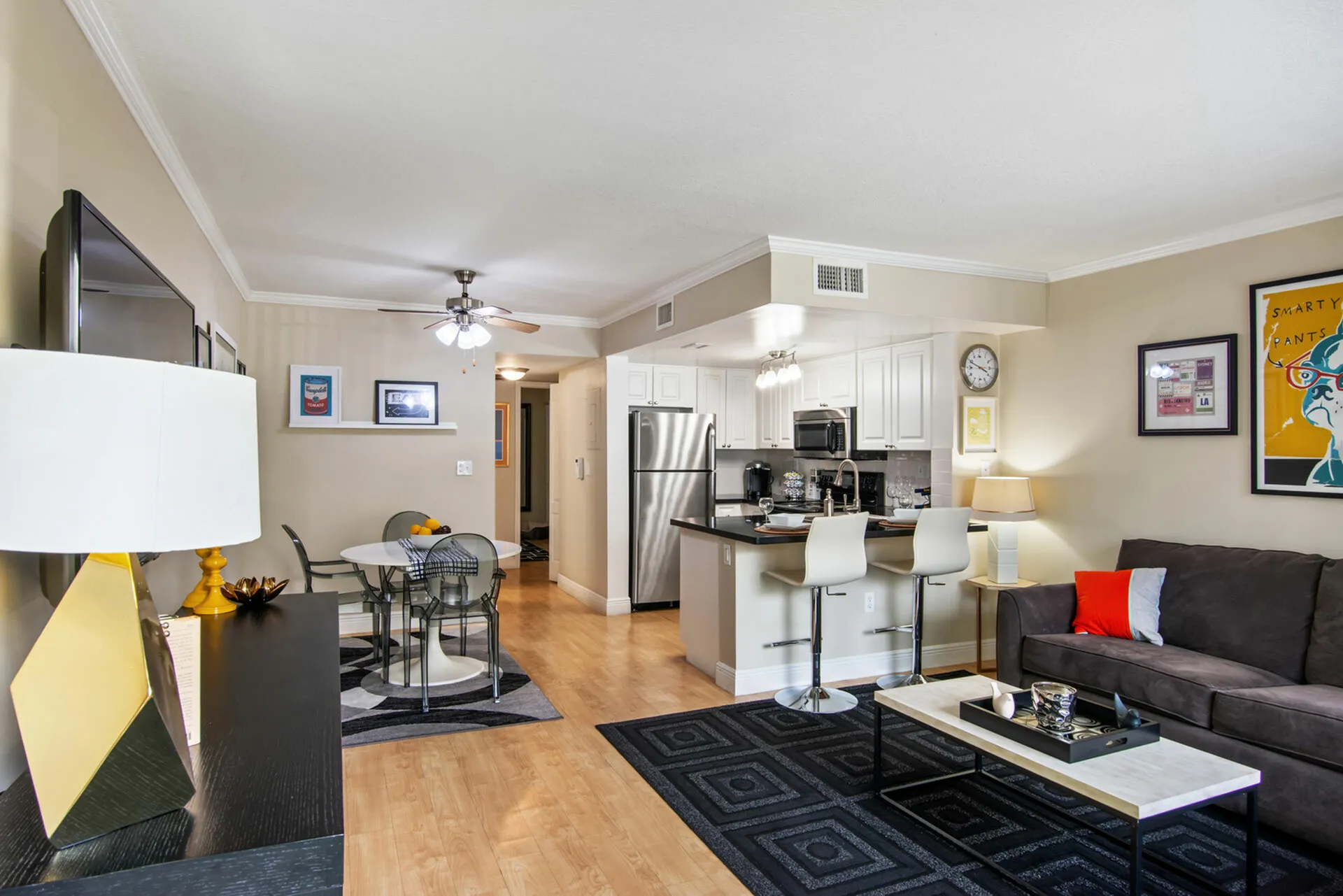 Bright and modern open-concept apartment featuring a cozy living area, sleek kitchen with breakfast bar, and stylish dining space.