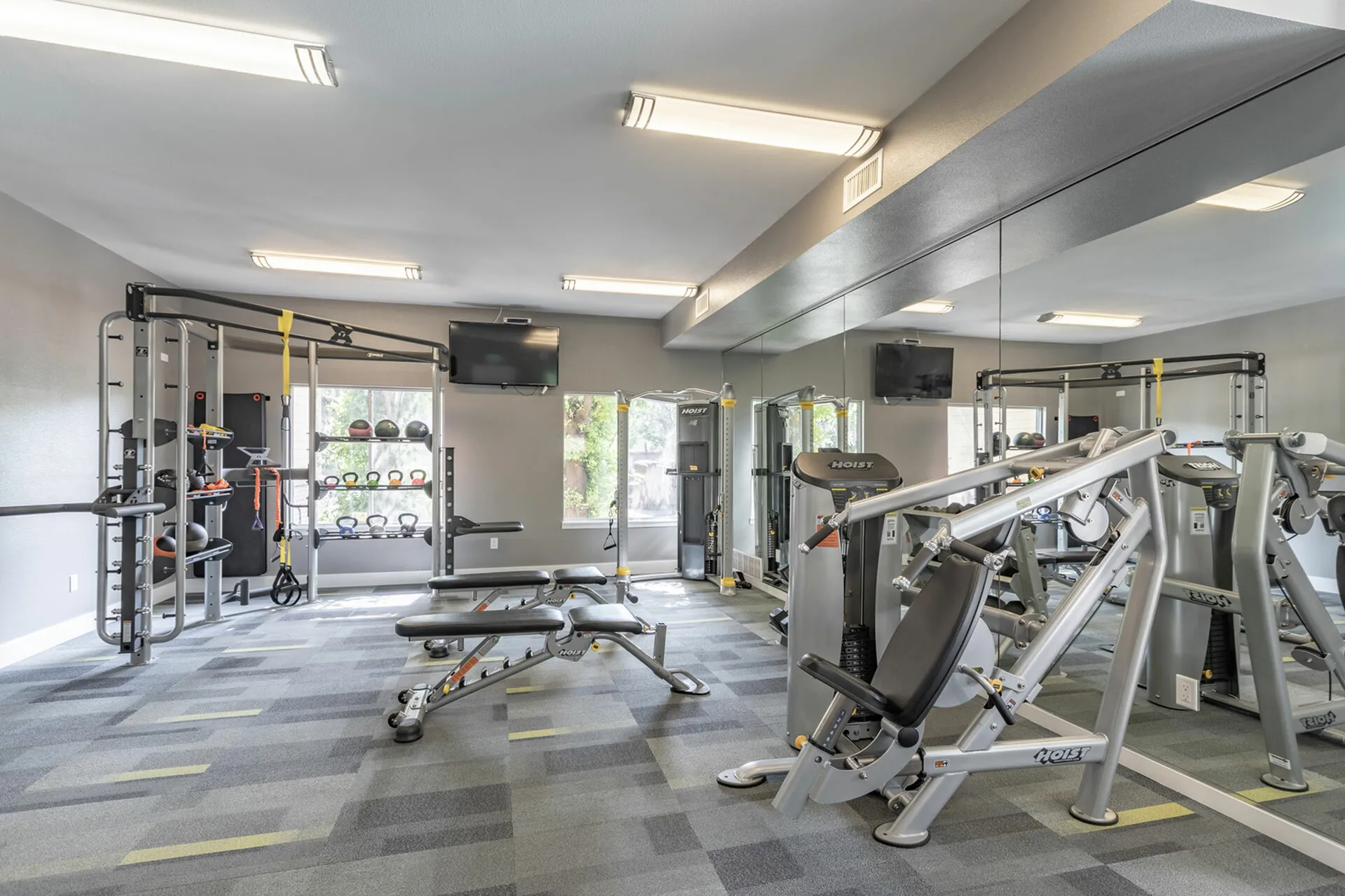 Modern gym with cutting-edge exercise equipment and mirrored walls.