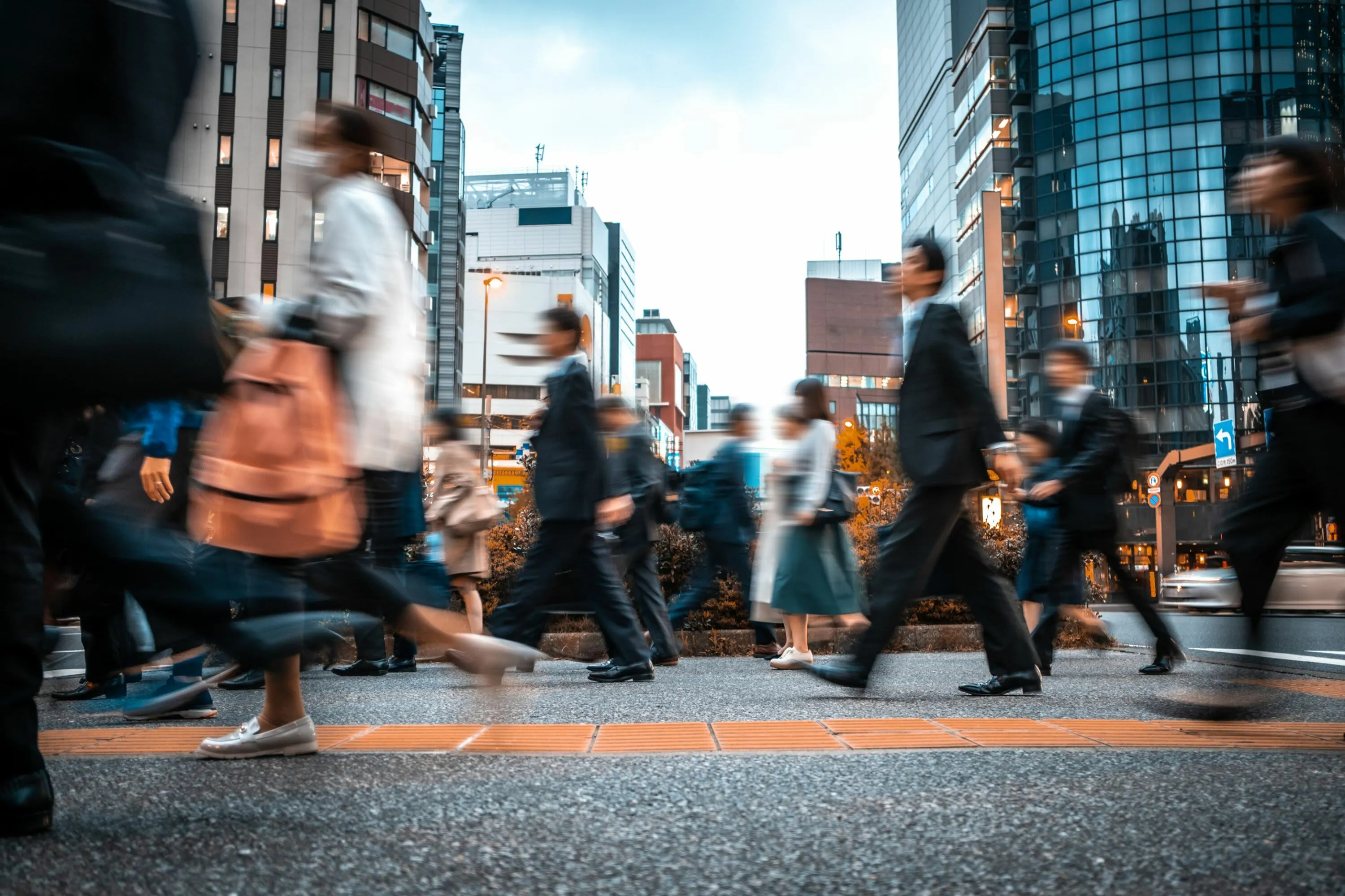 Dynamic cityscape with people in motion, surrounded by towering modern buildings under a vibrant sky.