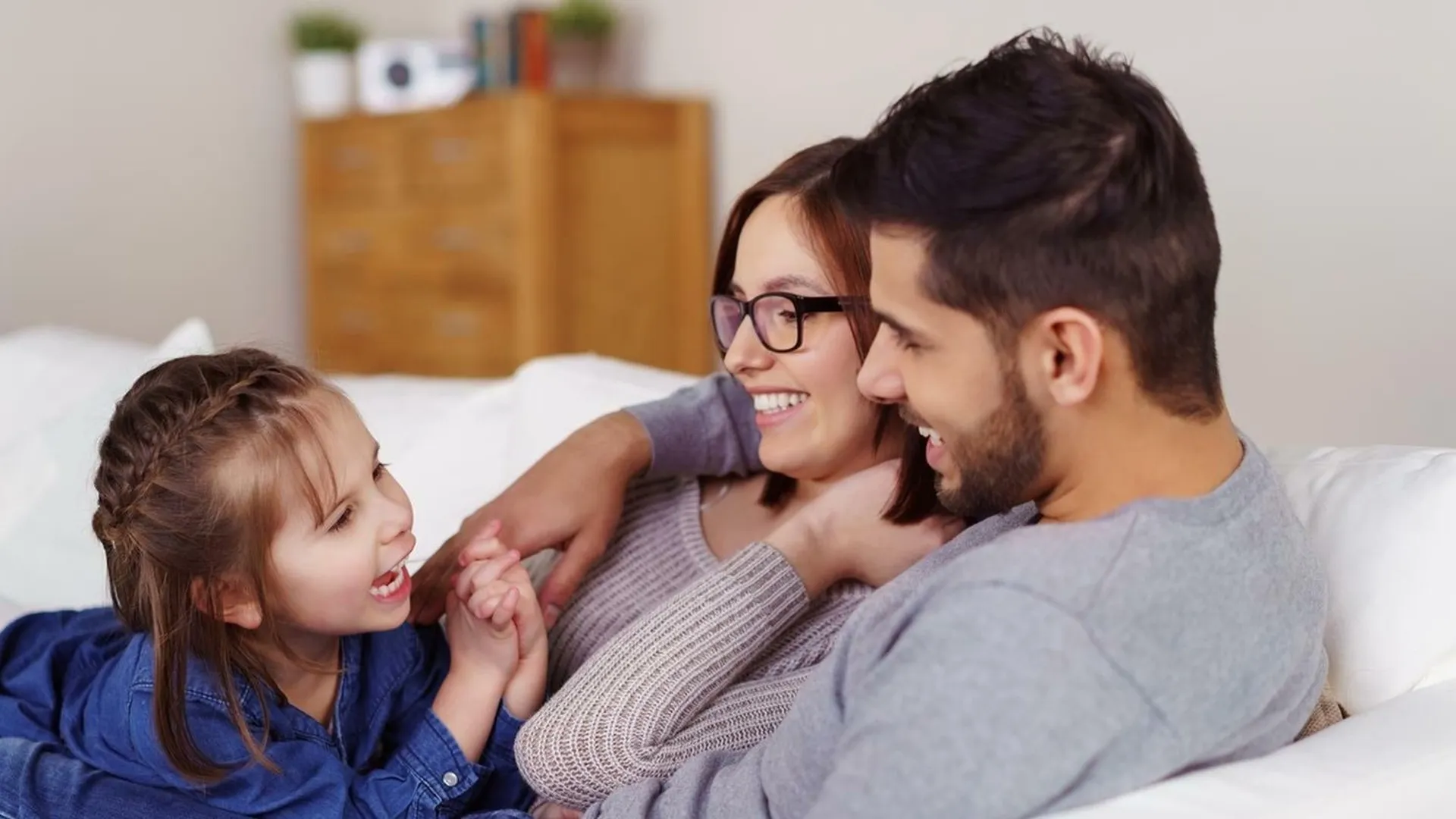 A family sitting on a couch at The Hickory at Indian Lake Village apartments for rent Hendersonville, TN.