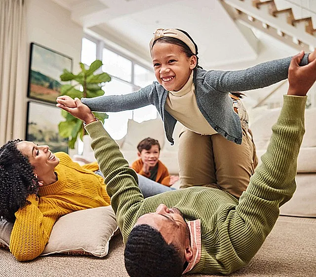 Bright and inviting living room with a playful family enjoying quality time, highlighting cozy space and natural light.