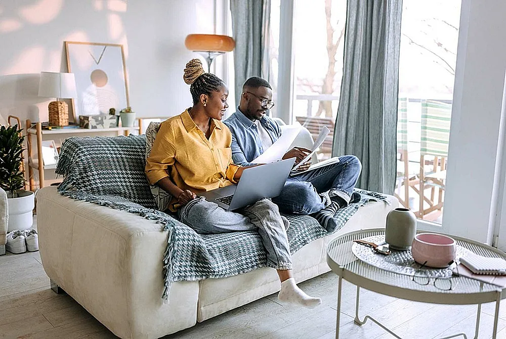 Bright and cozy living room with a modern sofa, stylish decor, and a peaceful balcony view, perfect for relaxation and home office space.