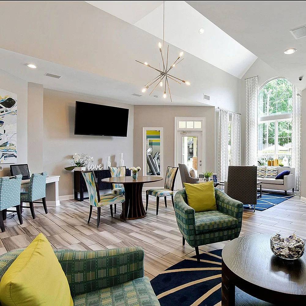 Elegant and airy communal lounge featuring modern seating, vibrant decor, and large windows that invite natural light.