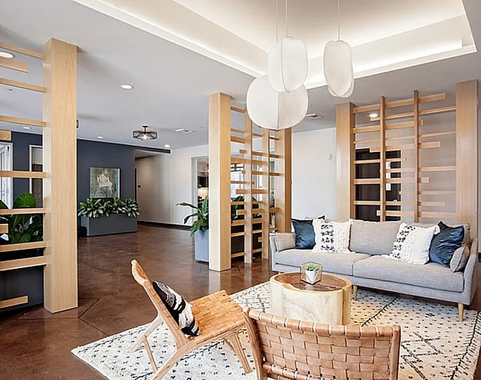 Elegant and modern living space featuring stylish wooden accents, cozy seating, and chic decor with abundant natural light.