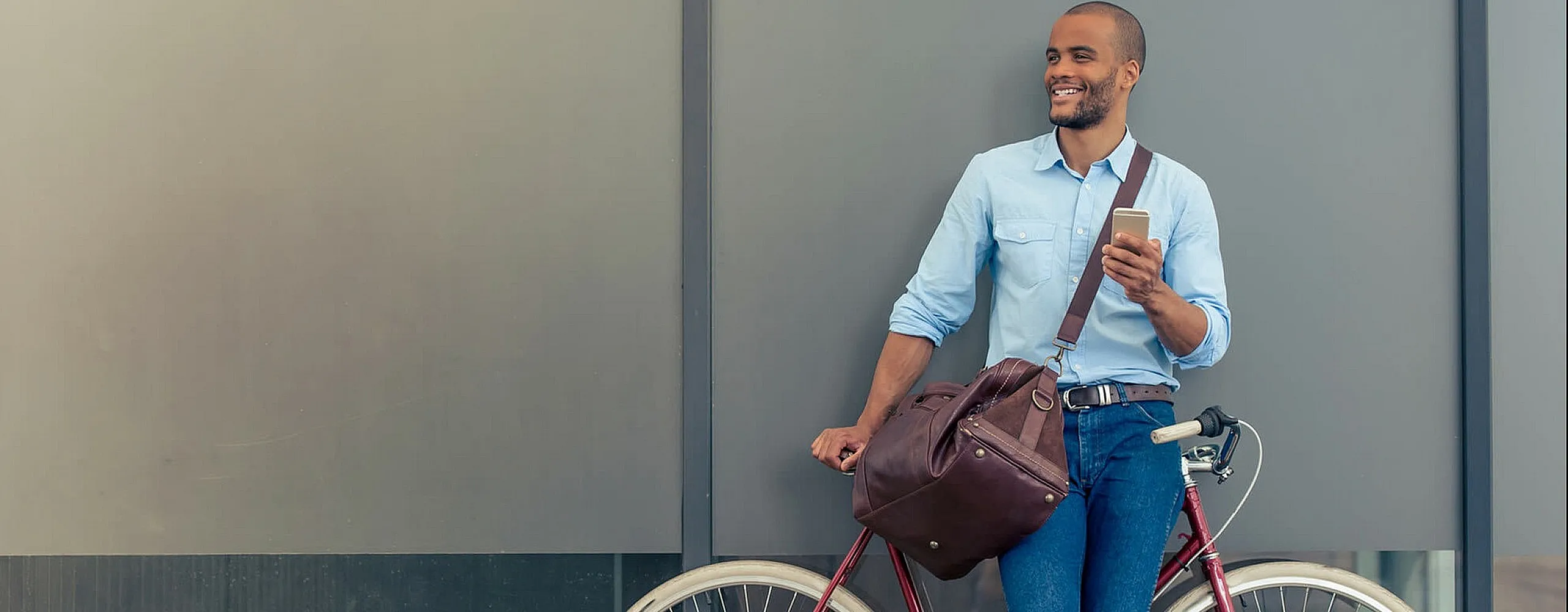 Modern urban lifestyle with a stylish man holding a smartphone and leaning on a sleek bicycle, exuding confidence and connectivity.