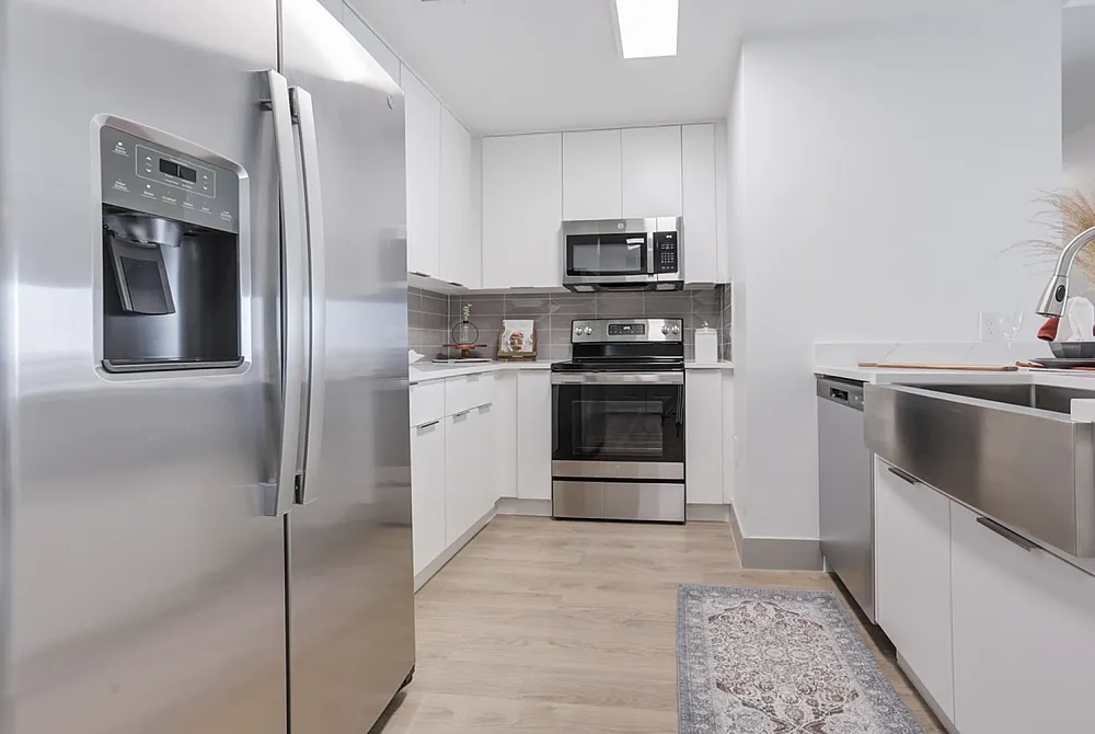 Chic modern kitchen design with sleek stainless steel appl0iances, bright cabinetry, and elegant tile backsplash for a stylish culinary experience.