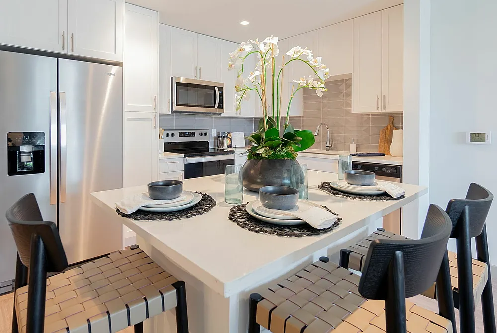 Luxurious apartment complex with stunning pool area, lush palm trees, and ample lounge seating offering a serene tropical oasis.