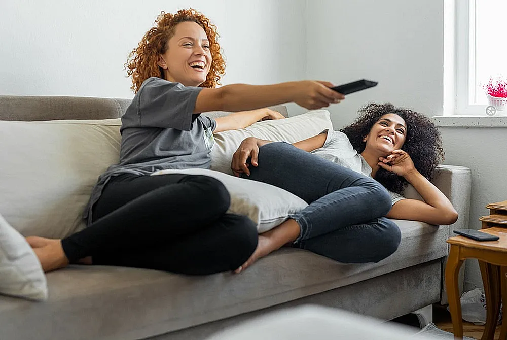 Cozy living room setting with two people relaxing on a comfortable sofa, enhancing a warm and inviting home atmosphere.