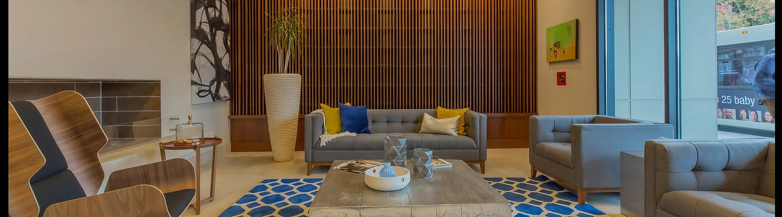 Modern apartment courtyard with stylish outdoor seating, vibrant red umbrellas, and lush greenery, perfect for relaxation and social gatherings.
