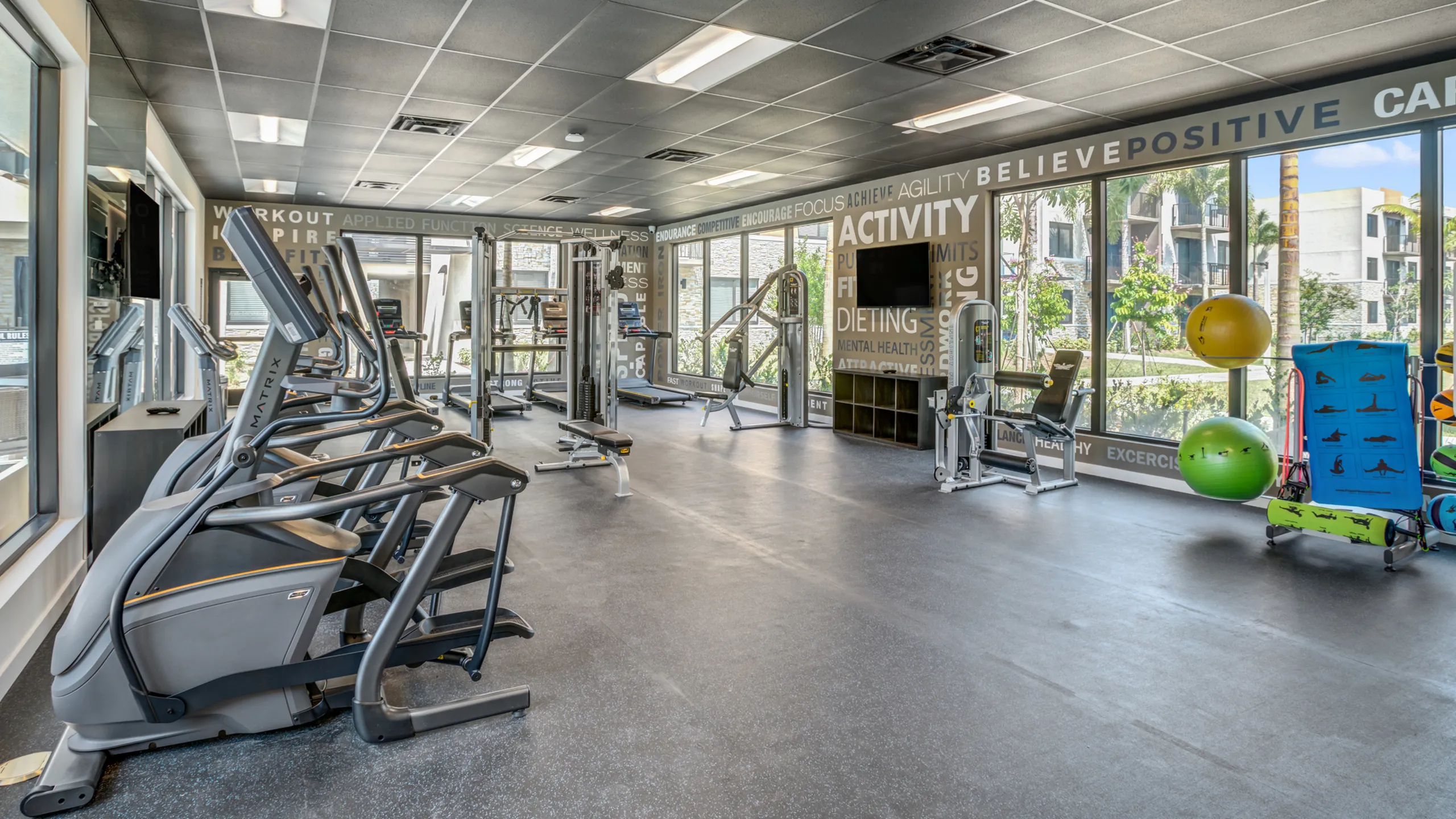 Fitness center with decorative walls and cardio and weight training machines