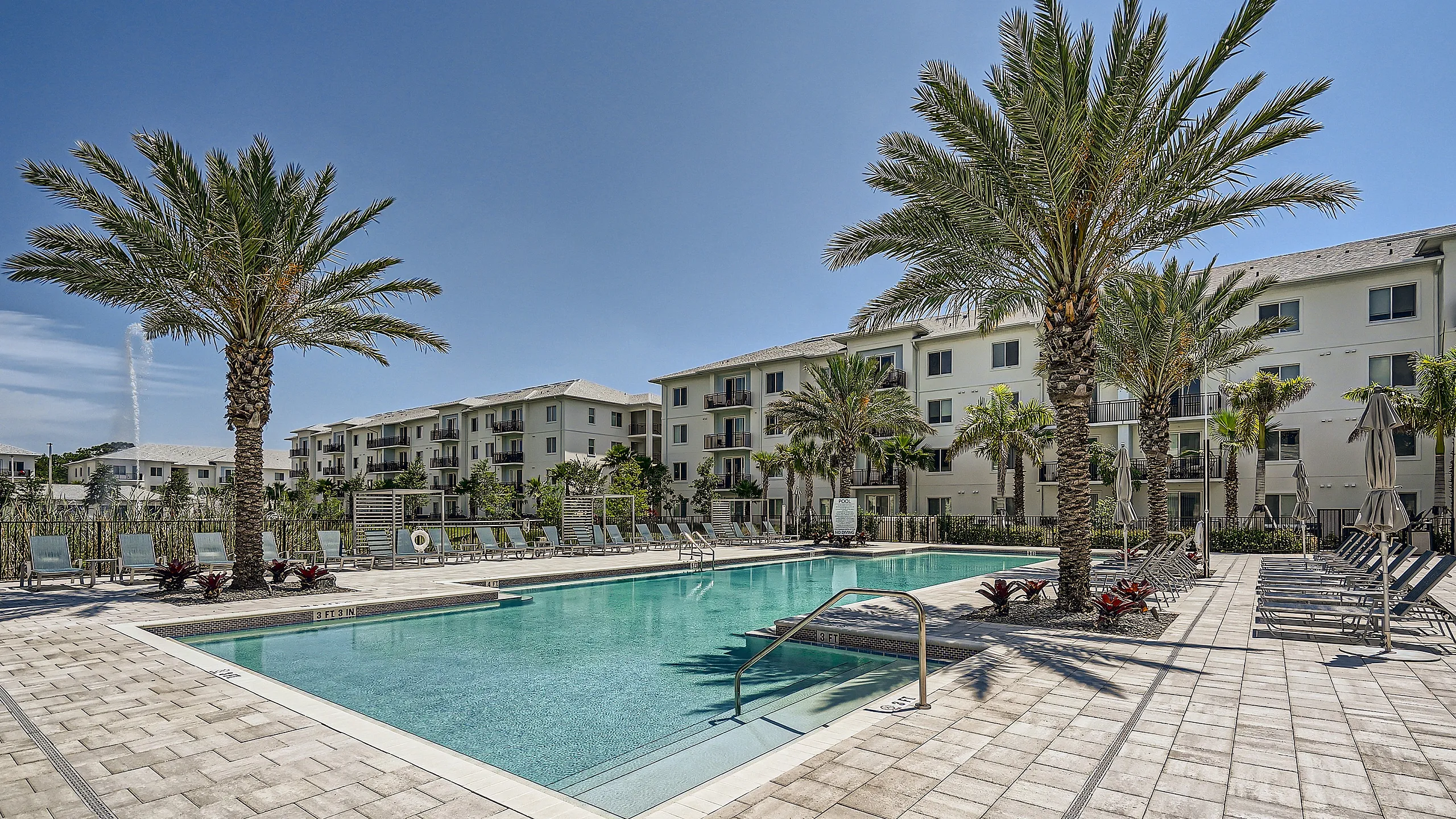 expansive swimming pool with sundeck and fountain lake