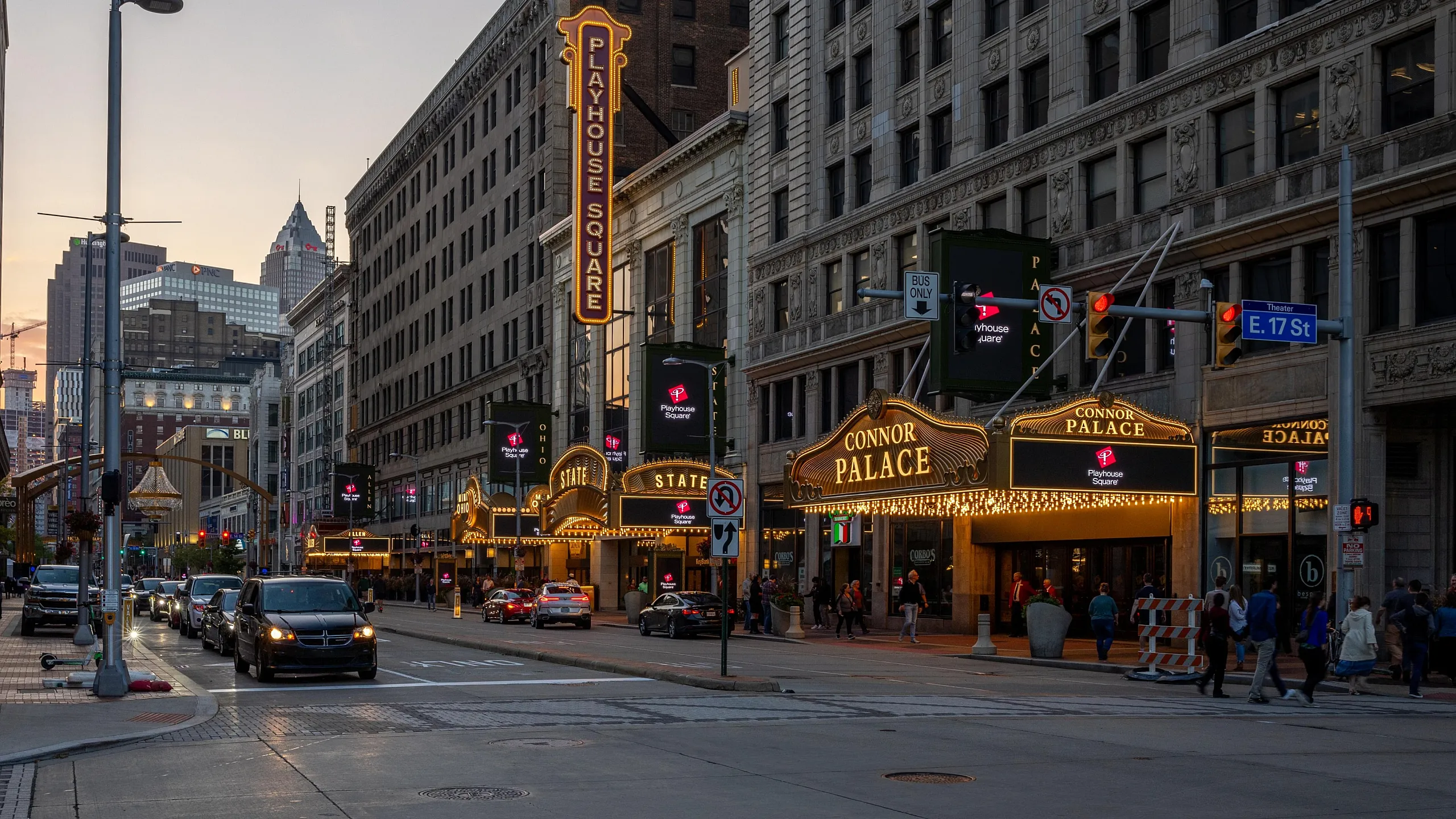Dynamic urban evening scene with illuminated theater signs and bustling street activity.