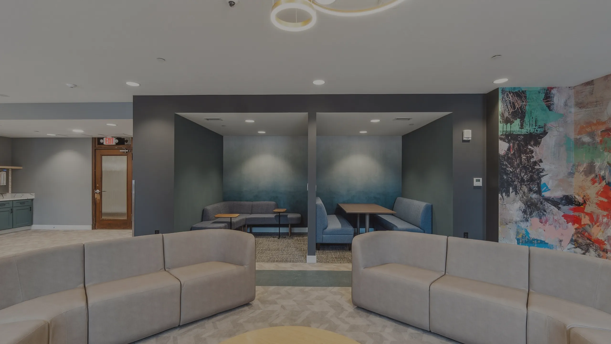 Contemporary lounge area with stylish seating, artistic wall mural, and intimate seating nooks, perfect for relaxation and socializing.