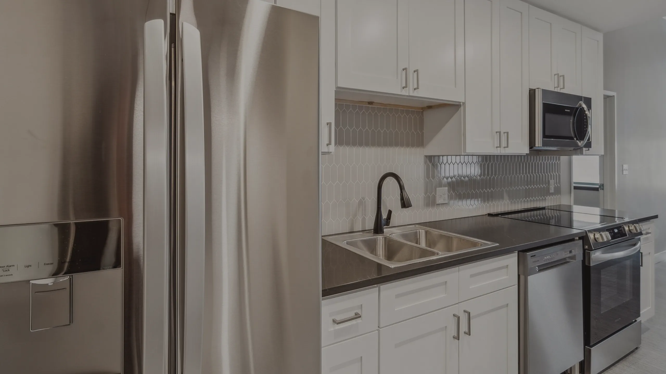 Modern kitchen with sleek stainless steel appliances, elegant cabinetry, and a stylish hexagonal tile backsplash.
