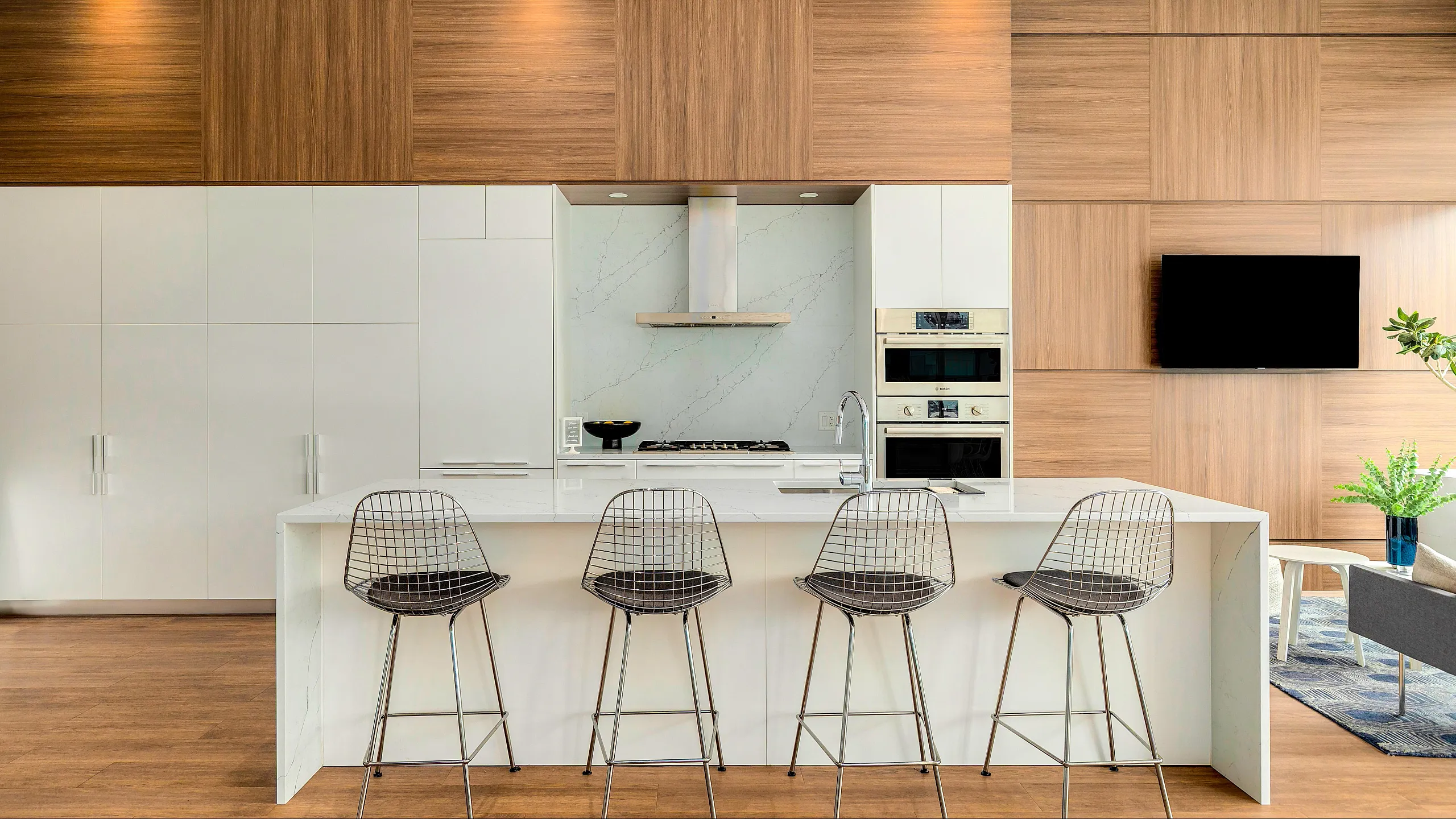 Sleek modern kitchen with a central island, high-quality appliances, and chic bar stools, perfect for entertaining.