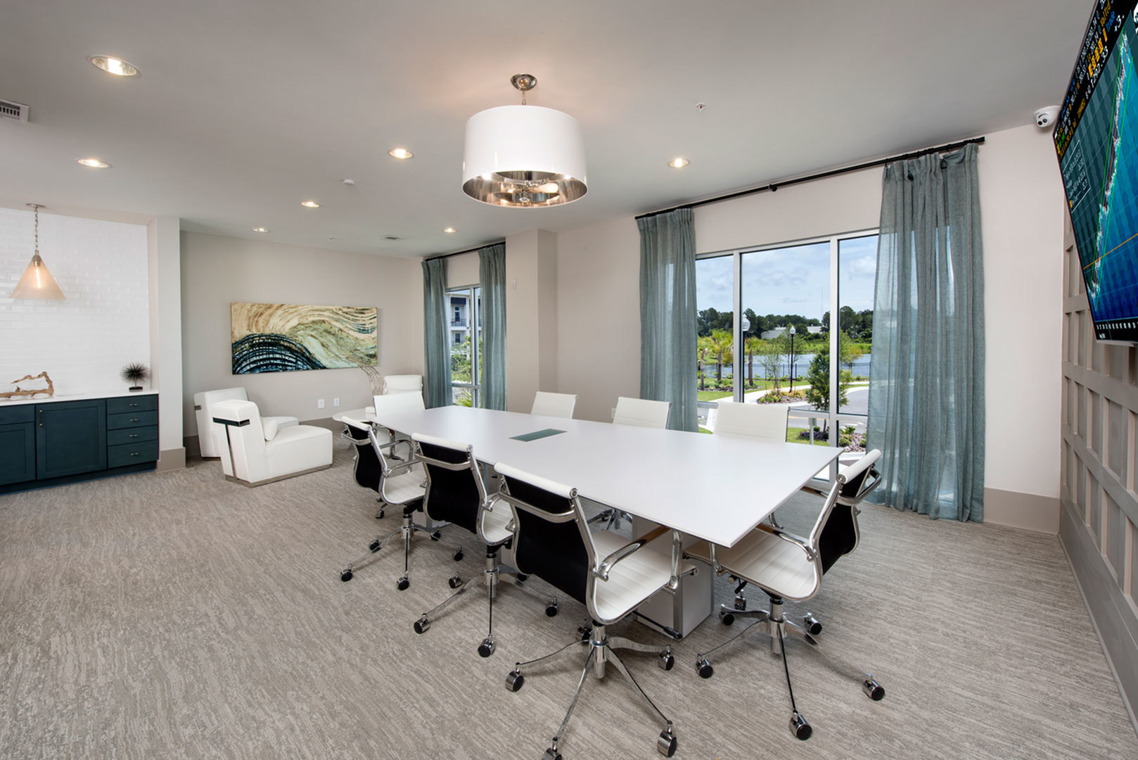 Elegant conference room with modern furniture, large windows offering scenic views, and stylish decor.