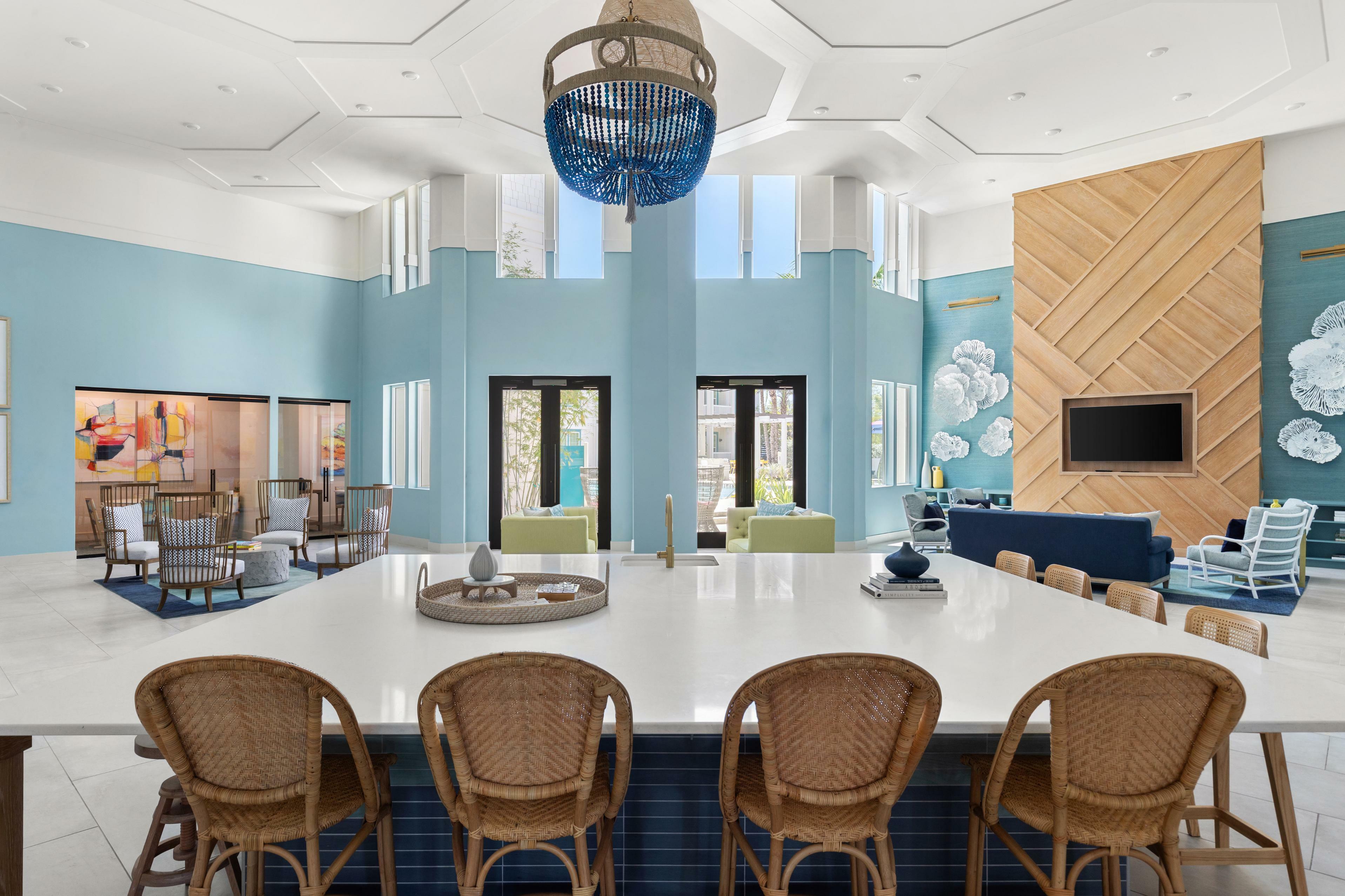 Sophisticated living space featuring elegant wicker chairs, modern decor, and ample natural light with a stunning high ceiling and stylish accents.