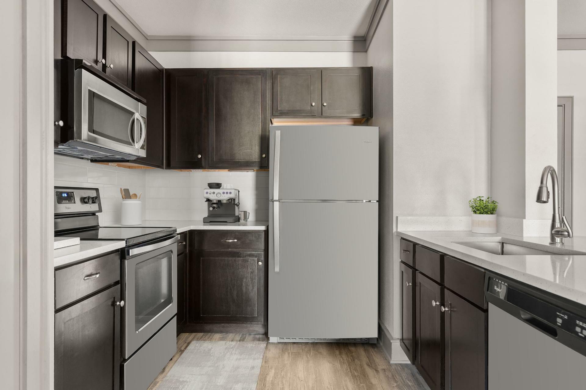 Modern kitchen with sleek dark wood cabinetry, stainless steel appliances, and a cozy coffee station, offering a stylish cooking experience.