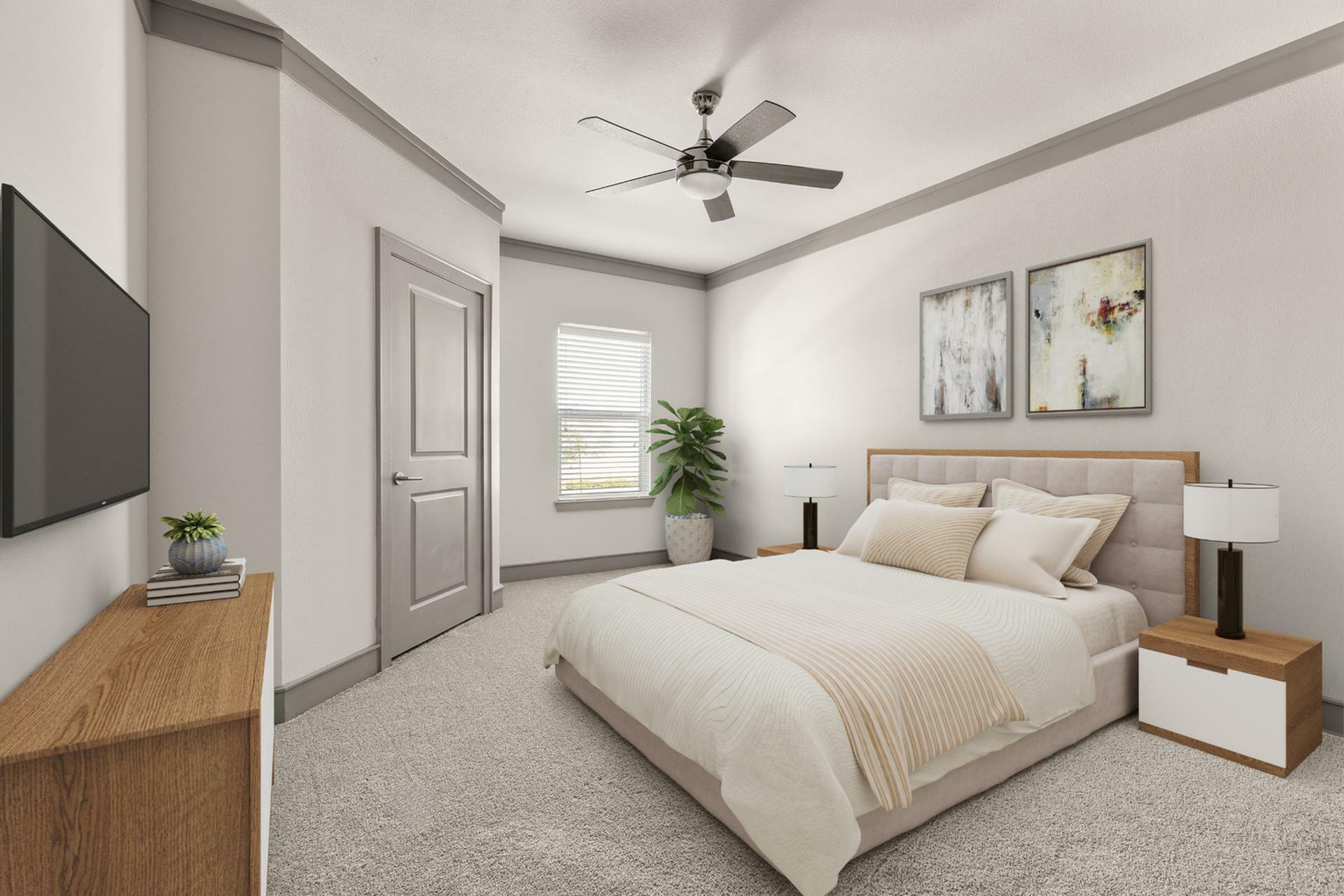Modern, cozy bedroom with plush carpeting, elegant bedding, stylish ceiling fan, and contemporary wall art for a serene ambiance.