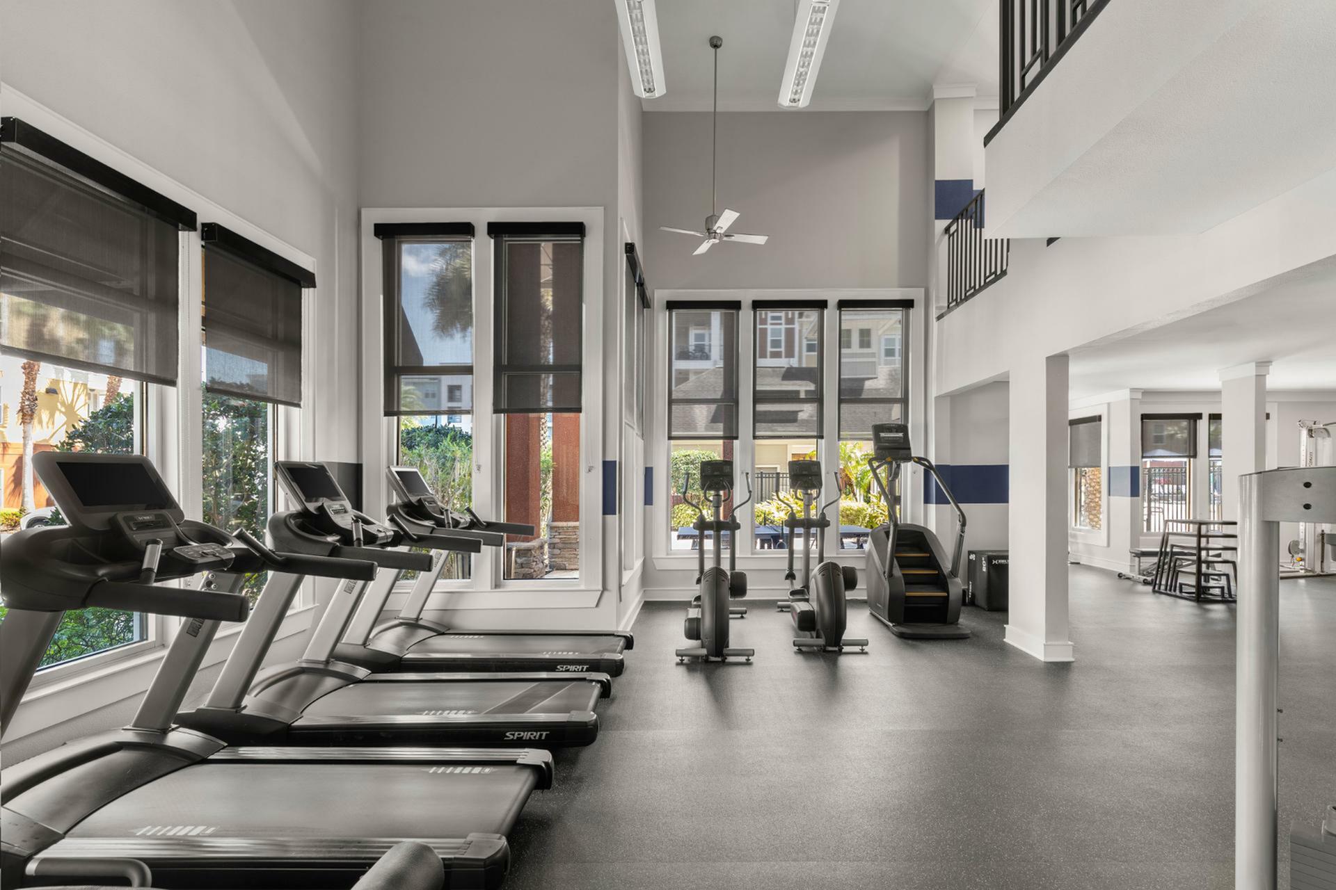 Bright and modern fitness center with state-of-the-art treadmills, ellipticals, and panoramic windows.