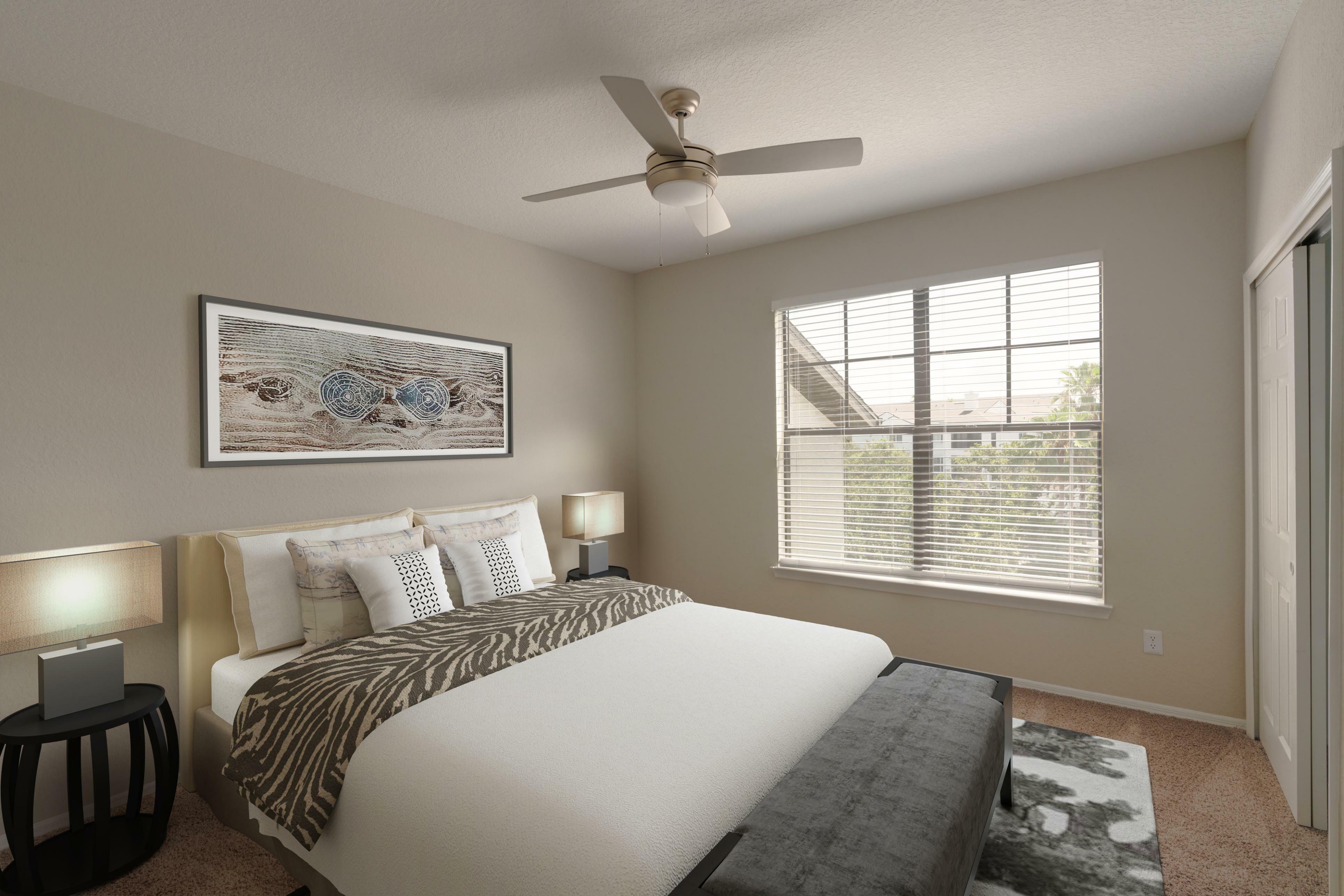 Inviting bedroom with plush bedding, modern ceiling fan, and large window offering natural light and charming views.