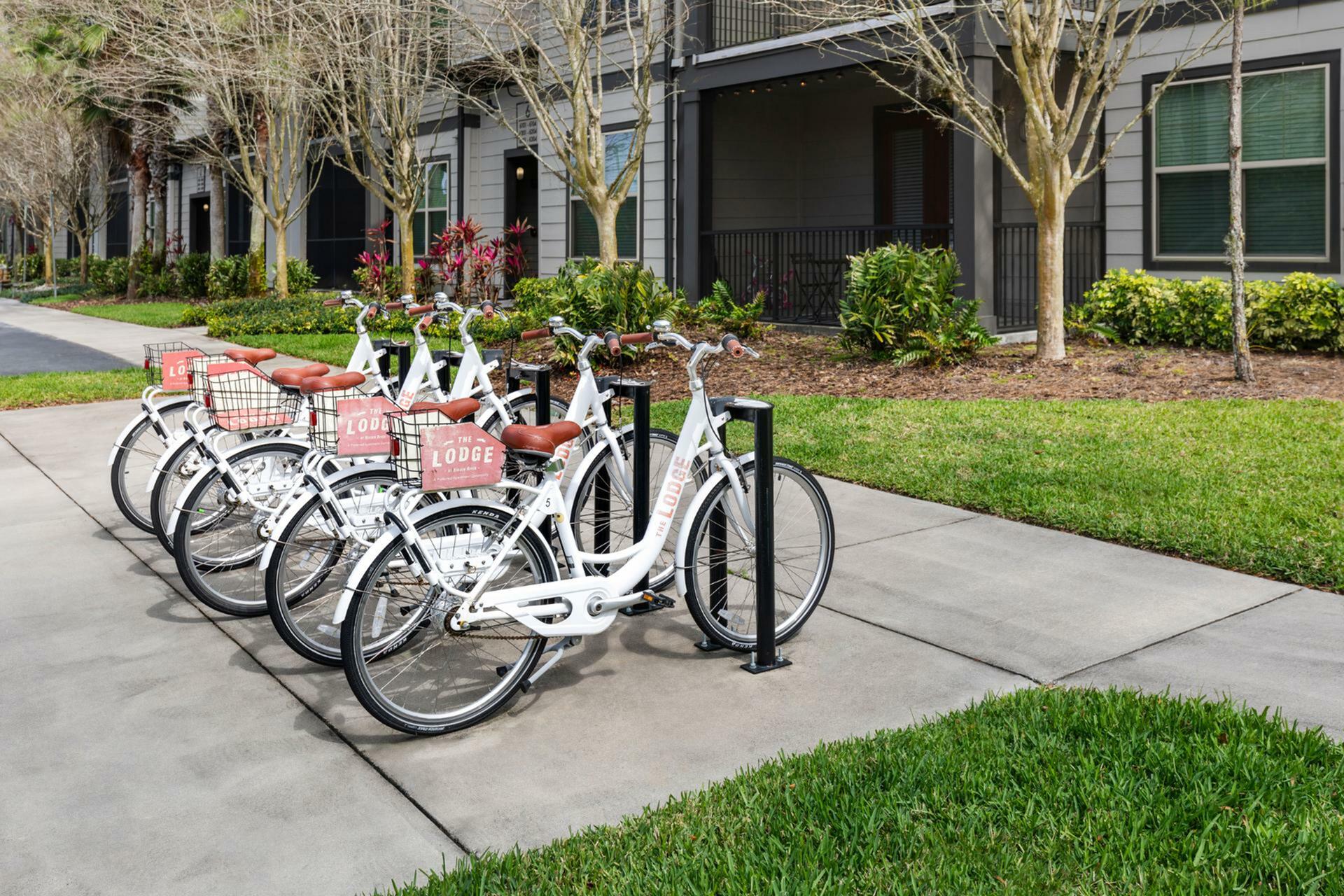 Charming apartment entrance with a dedicated bike rack and lush landscaping, ideal for an active lifestyle.