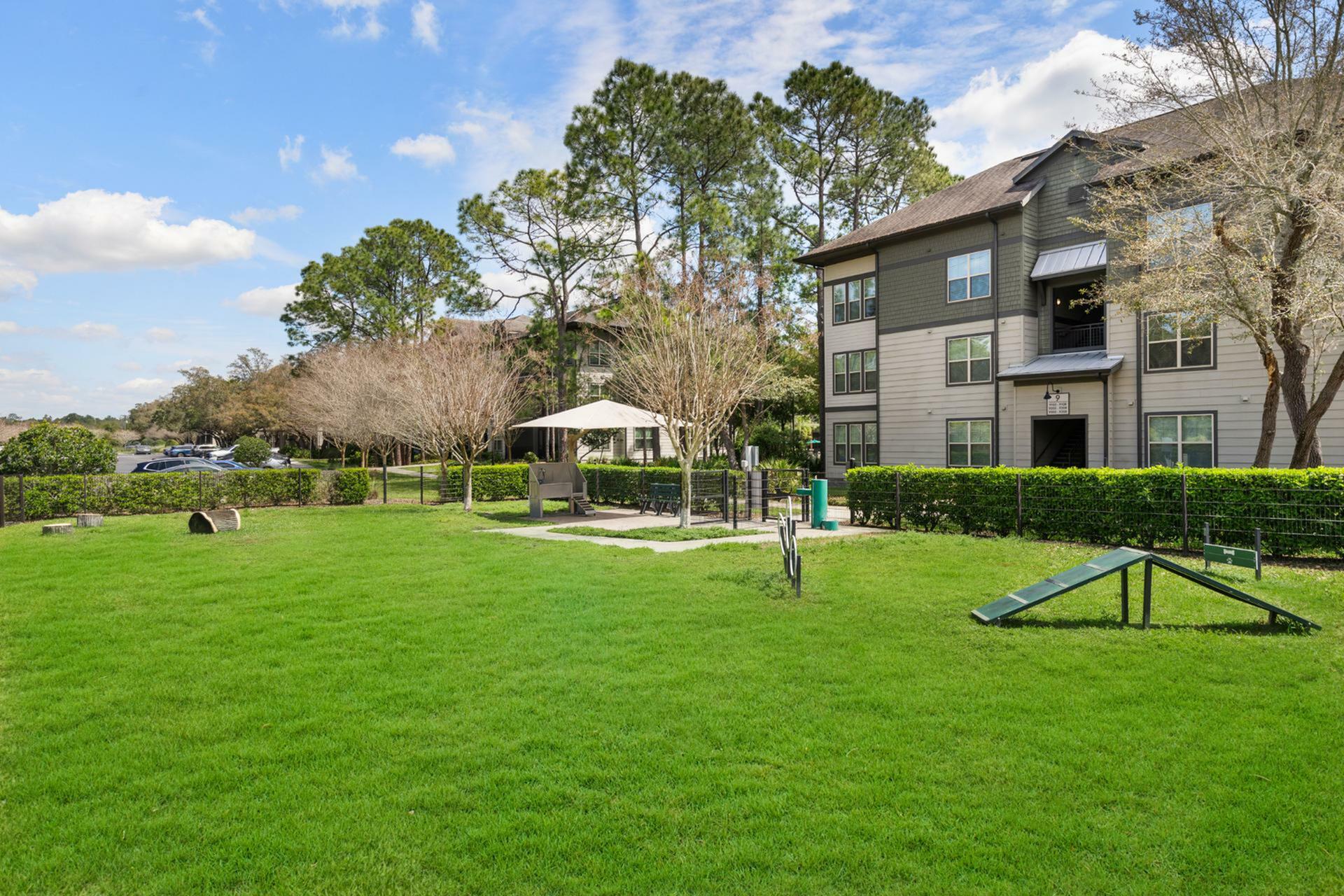 Charming apartment complex with lush green lawns, outdoor seating, and scenic surroundings perfect for relaxation.