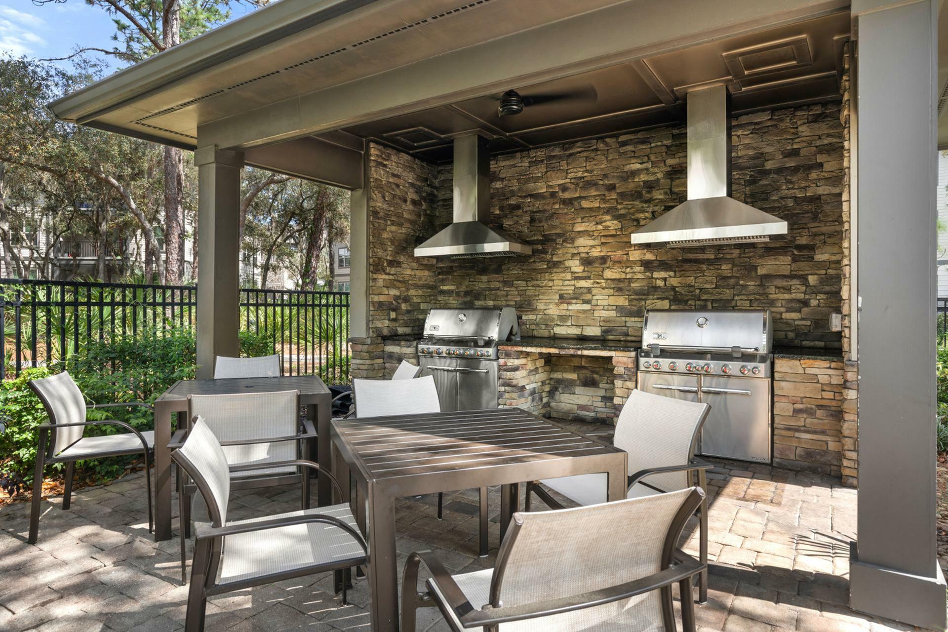 Inviting outdoor patio with modern grills and cozy seating, perfect for entertaining and enjoying nature.