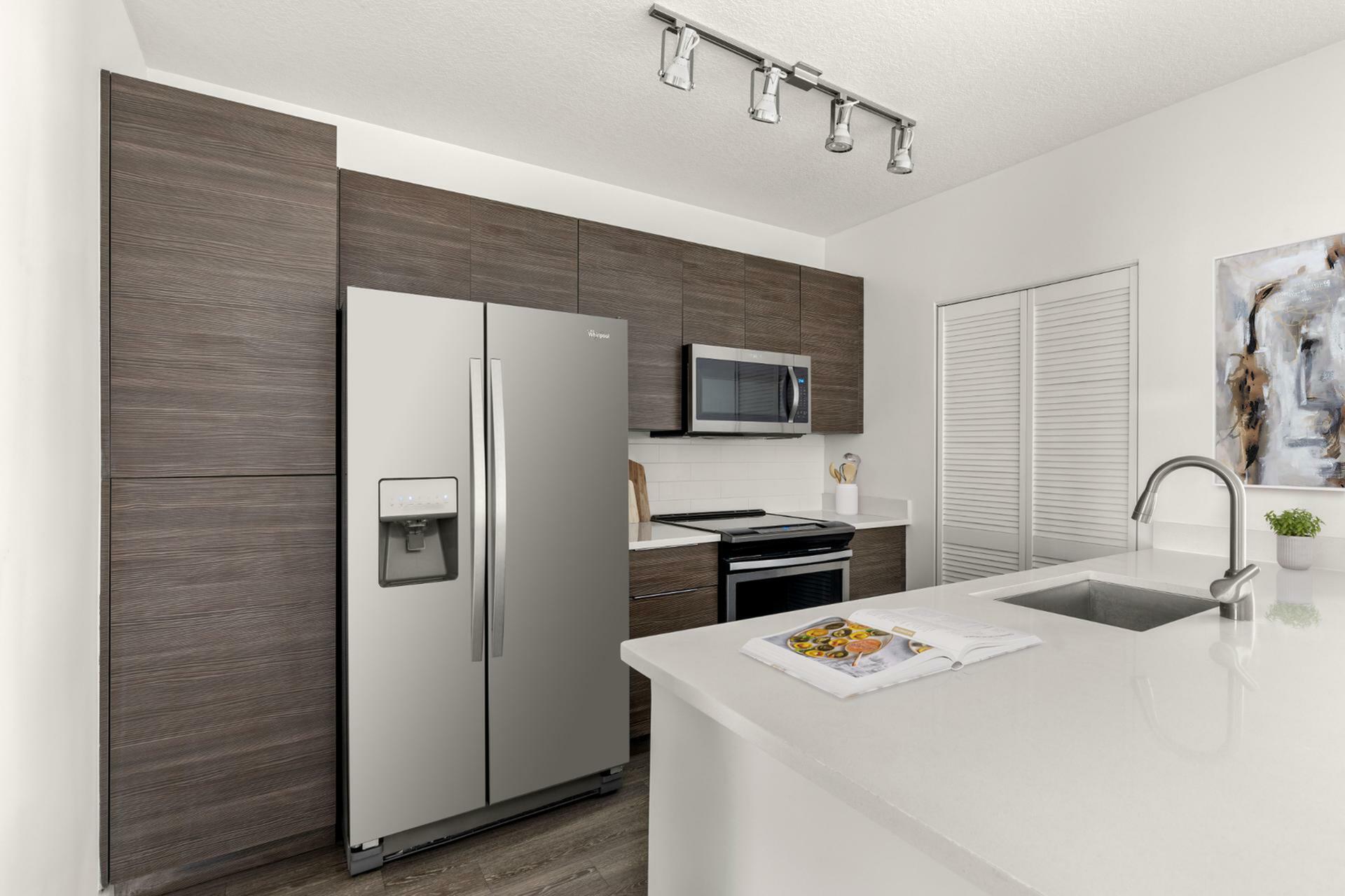 Sleek modern kitchen featuring stainless steel appliances, elegant dark wood cabinets, and a chic, white countertop island with stylish lighting.