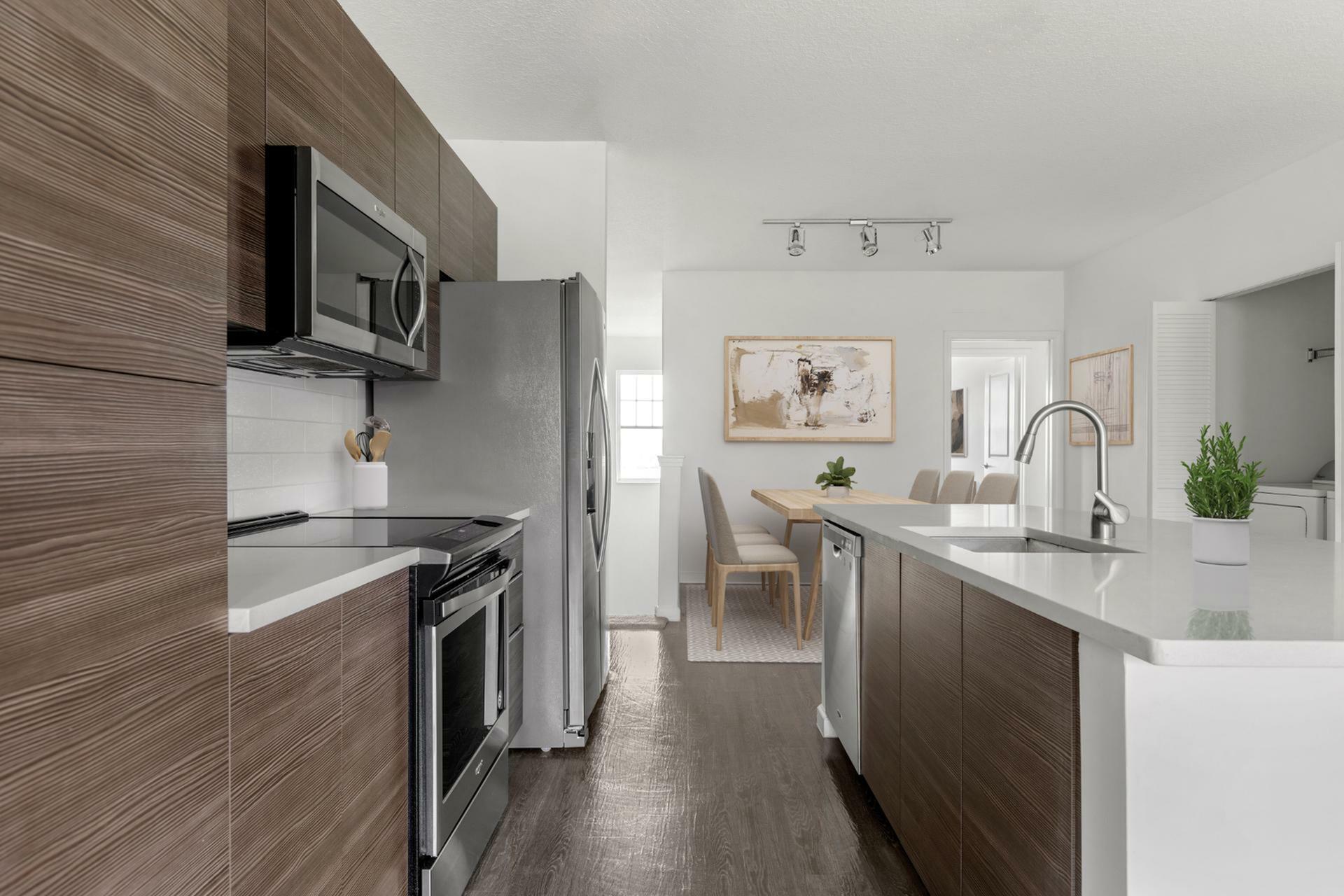Contemporary open-plan kitchen with sleek appliances and elegant dining area bathed in natural light.