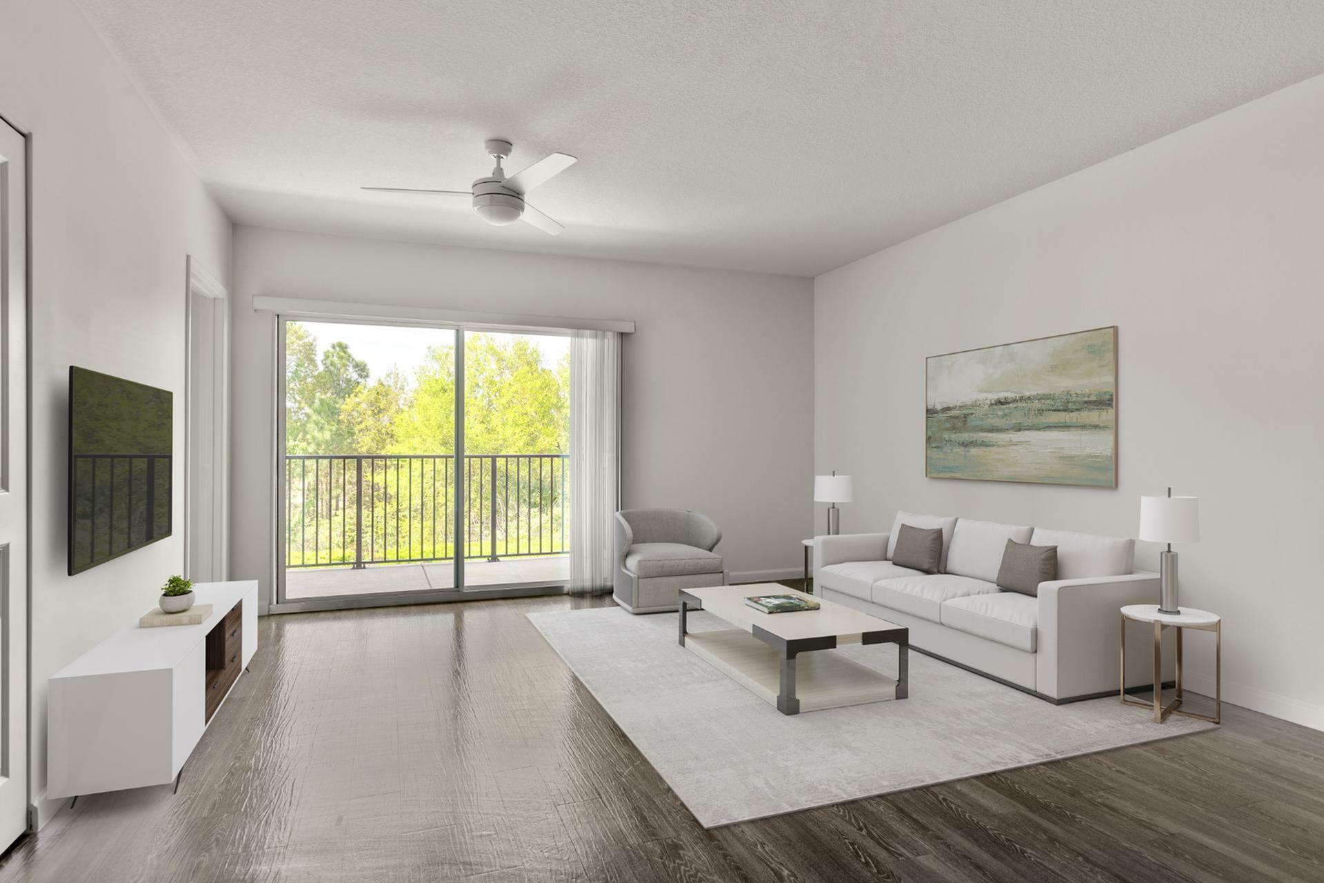 Bright and inviting living room featuring modern decor, elegant wooden flooring, and a scenic view through large sliding glass doors.