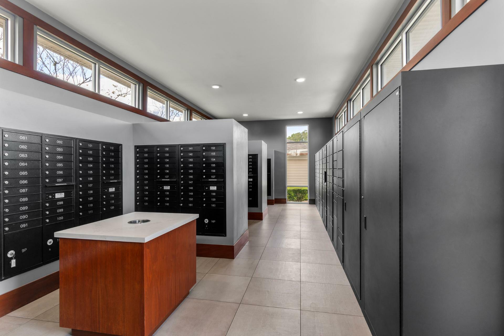 Modern apartment mailroom with sleek individual mailboxes and large windows providing ample natural light.