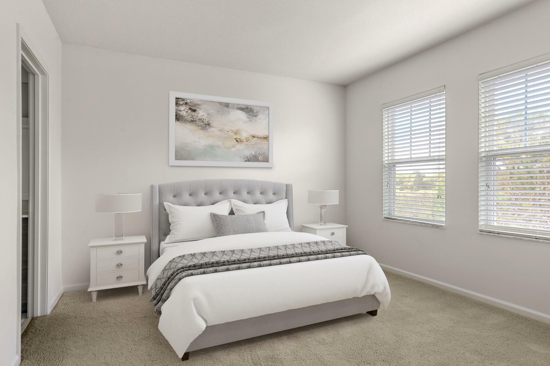Bright and elegant bedroom featuring a plush gray tufted headboard, modern side tables, and soft natural light streaming through large windows.