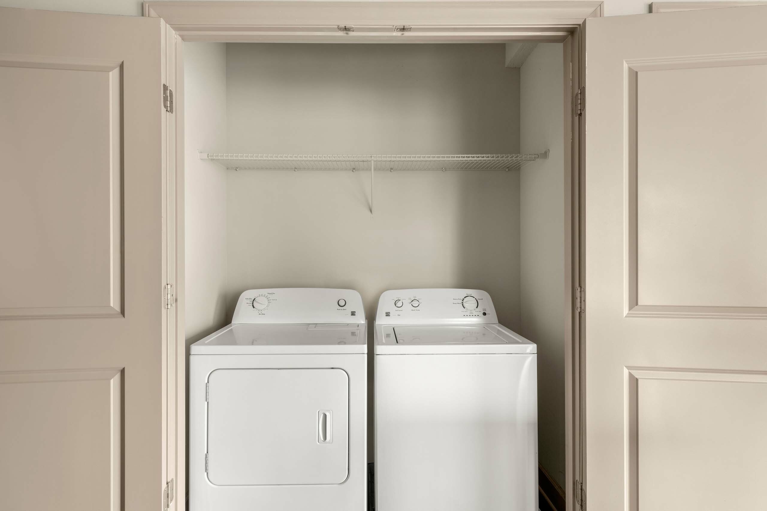 Modern laundry area with pristine washer and dryer set, optimally fitted in a sleek closet space.