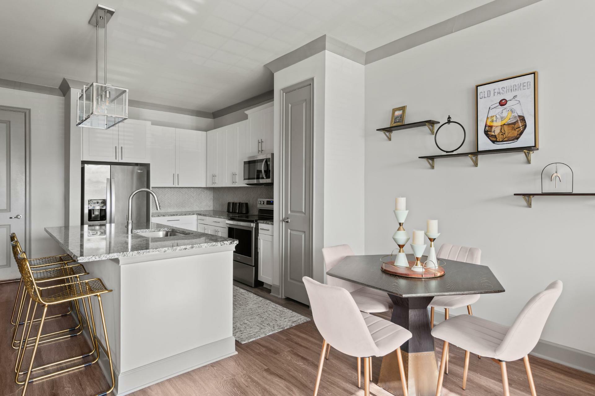 Chic modern kitchen with elegant marble countertops, stylish breakfast bar seating, and cozy dining nook in a spacious open-plan apartment.