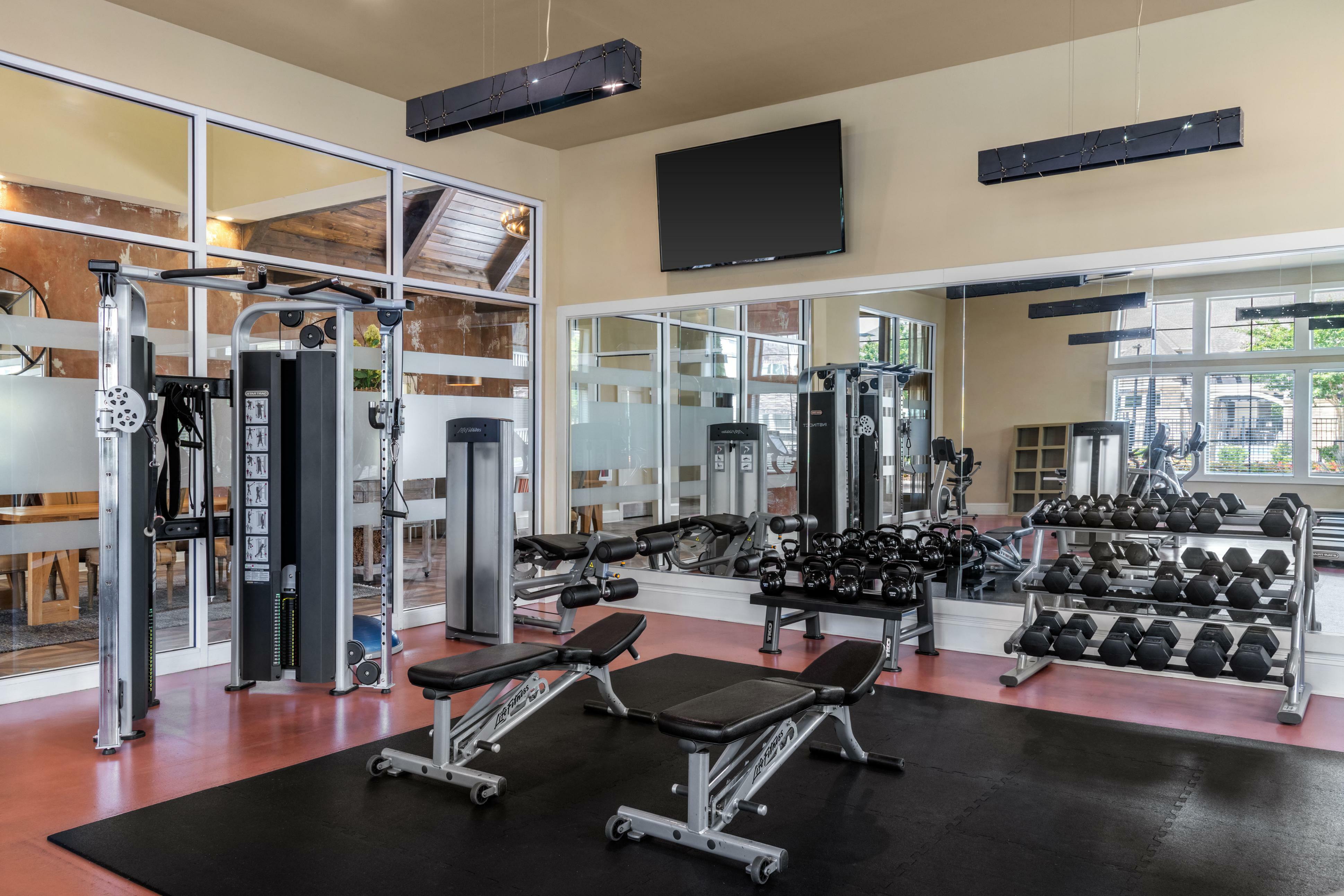 Modern fitness center with state-of-the-art gym equipment, free weights, and sleek mirrors for a complete workout experience.