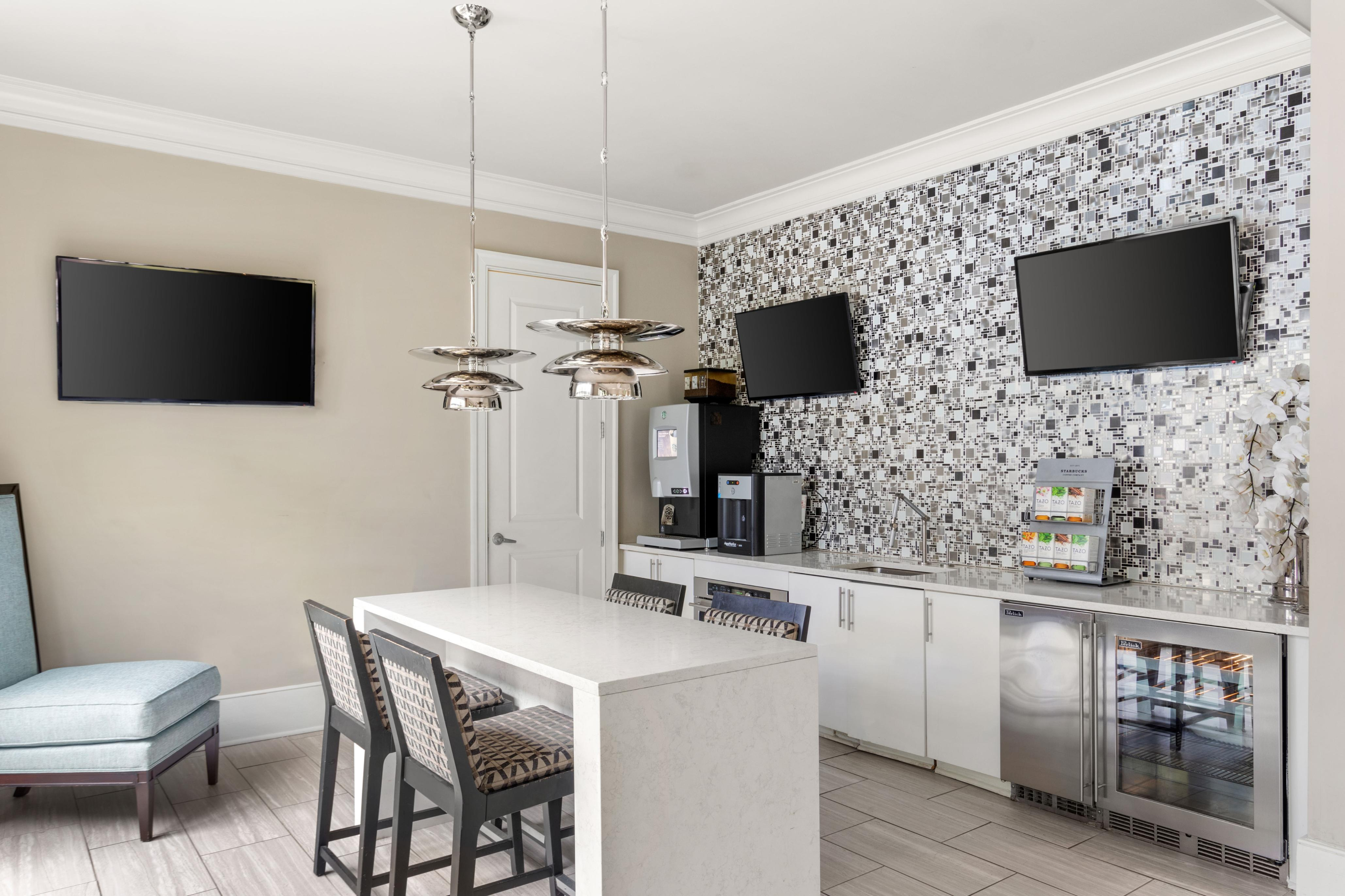 Chic kitchen area featuring stylish mosaic backsplash, modern appliances, and a sleek breakfast bar with elegant lighting.