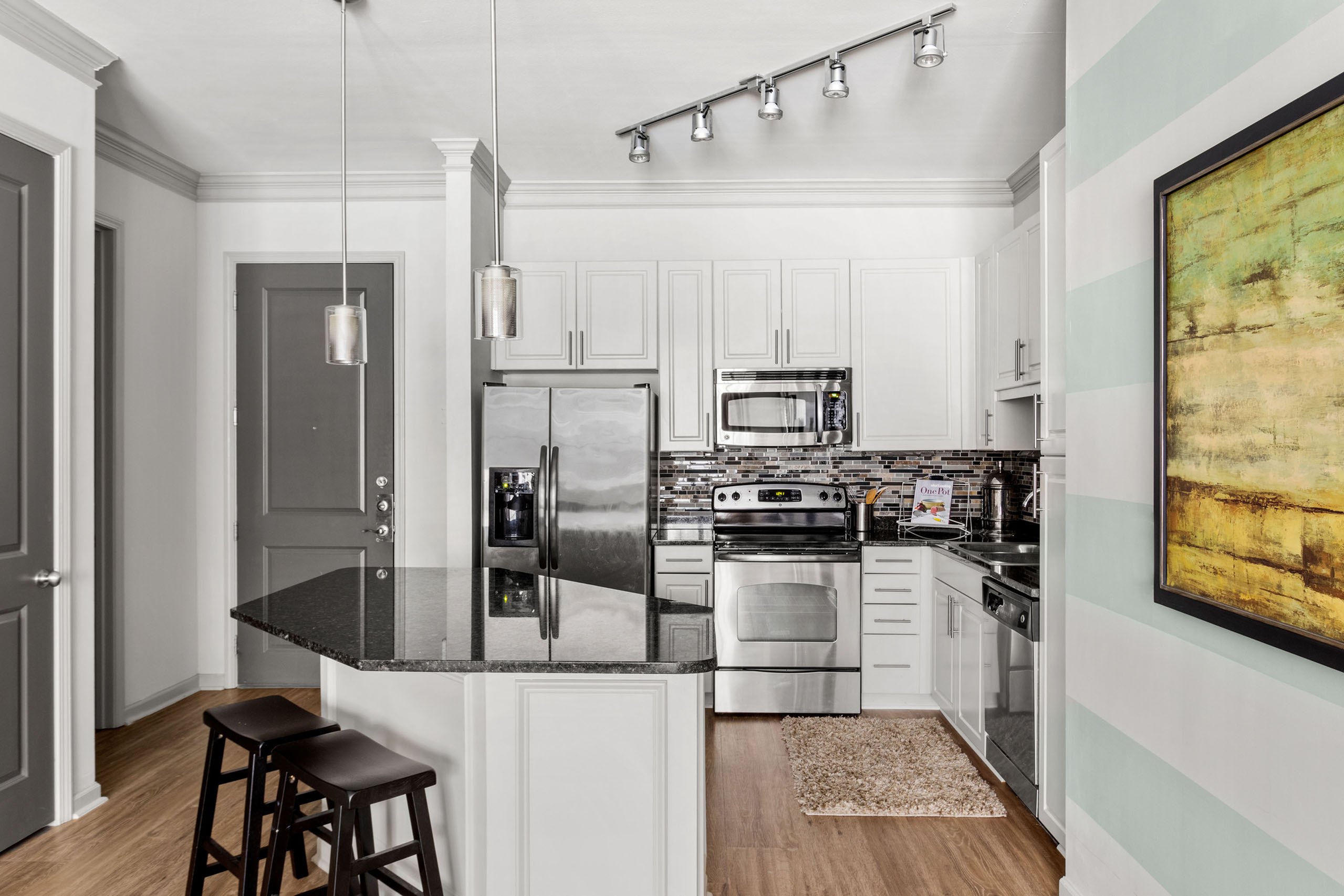 Contemporary kitchen with stainless steel appliances, sleek cabinetry, and elegant pendant lighting, creating a modern and inviting cooking space.