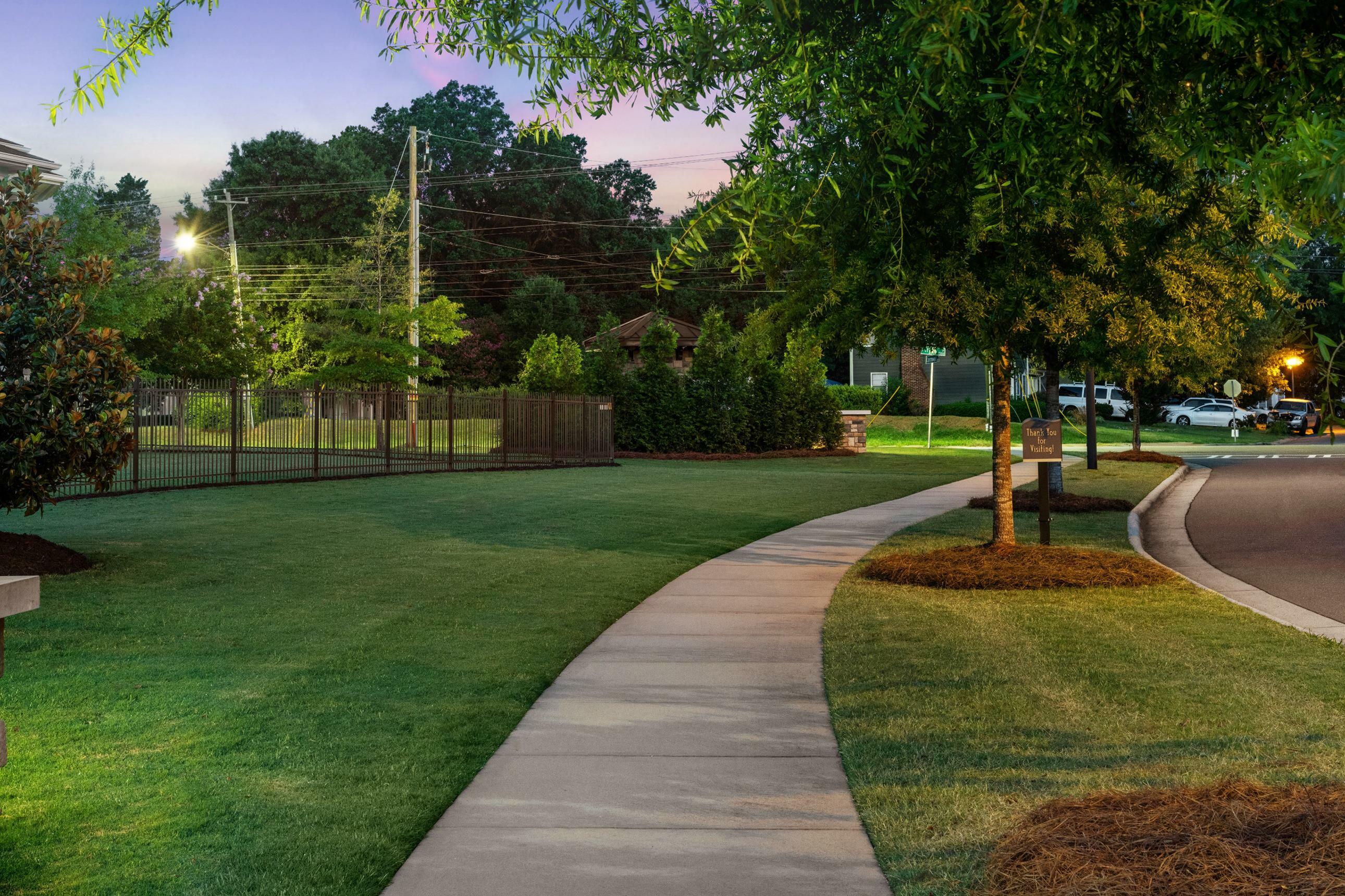 Charming landscaped walkway in a serene neighborhood park setting, perfect for evening strolls.