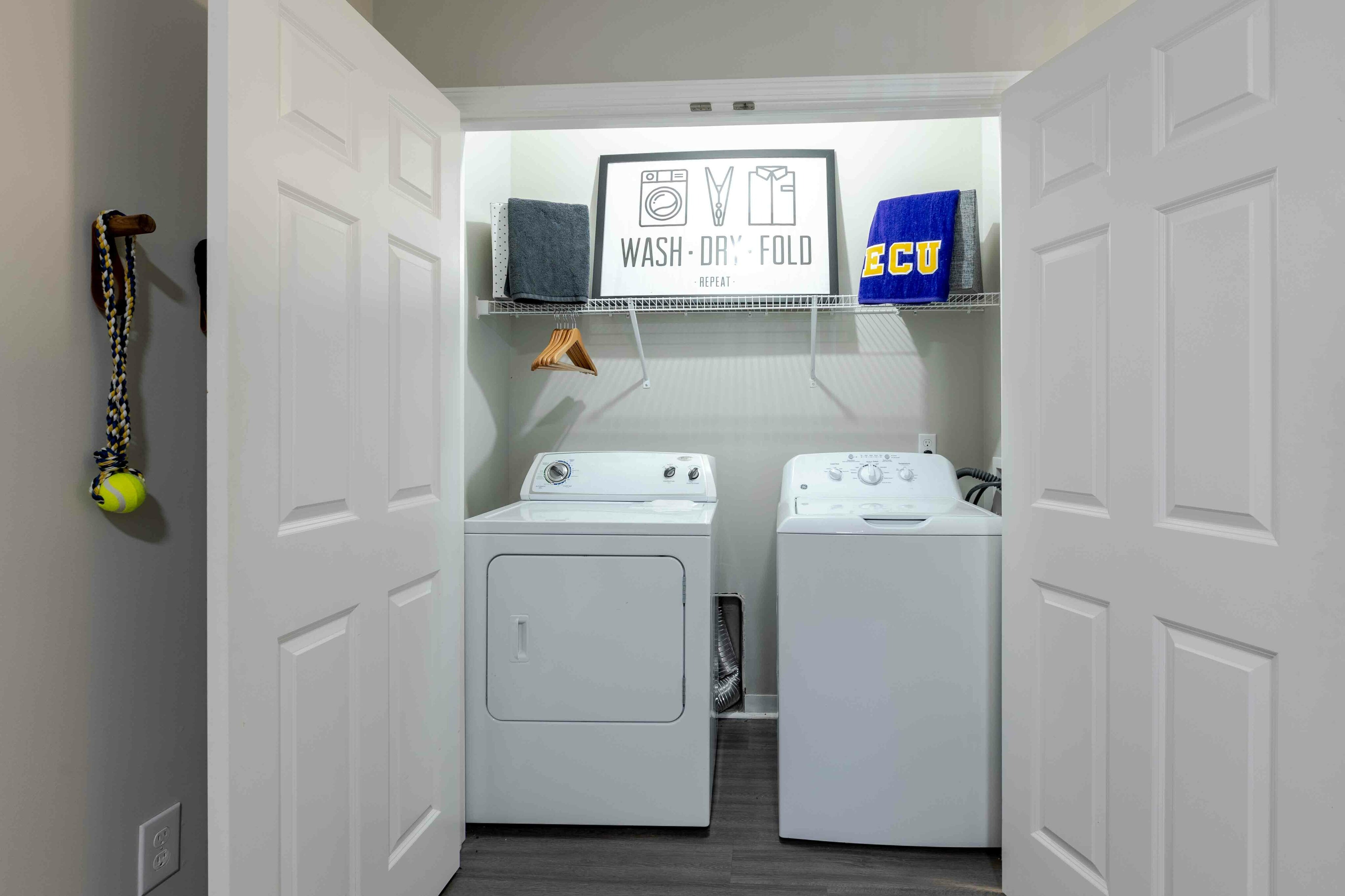 Model apartment laundry room with full size washer and dryer