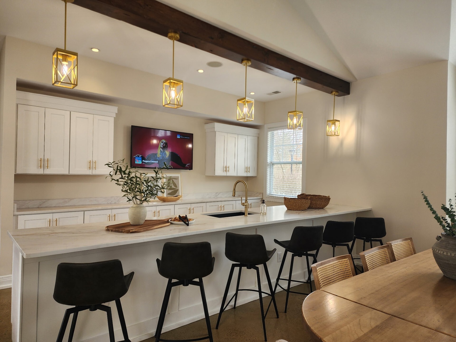 Chic kitchen space featuring elegant pendant lighting, a large island with seating, and modern cabinetry.